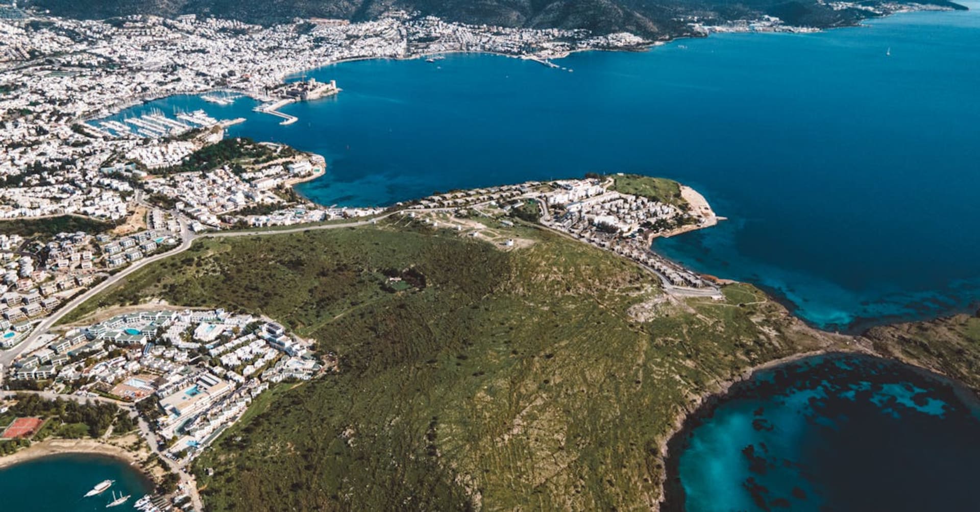 Whitewashed houses cascading down to Bodrum's harbor with the castle in the background