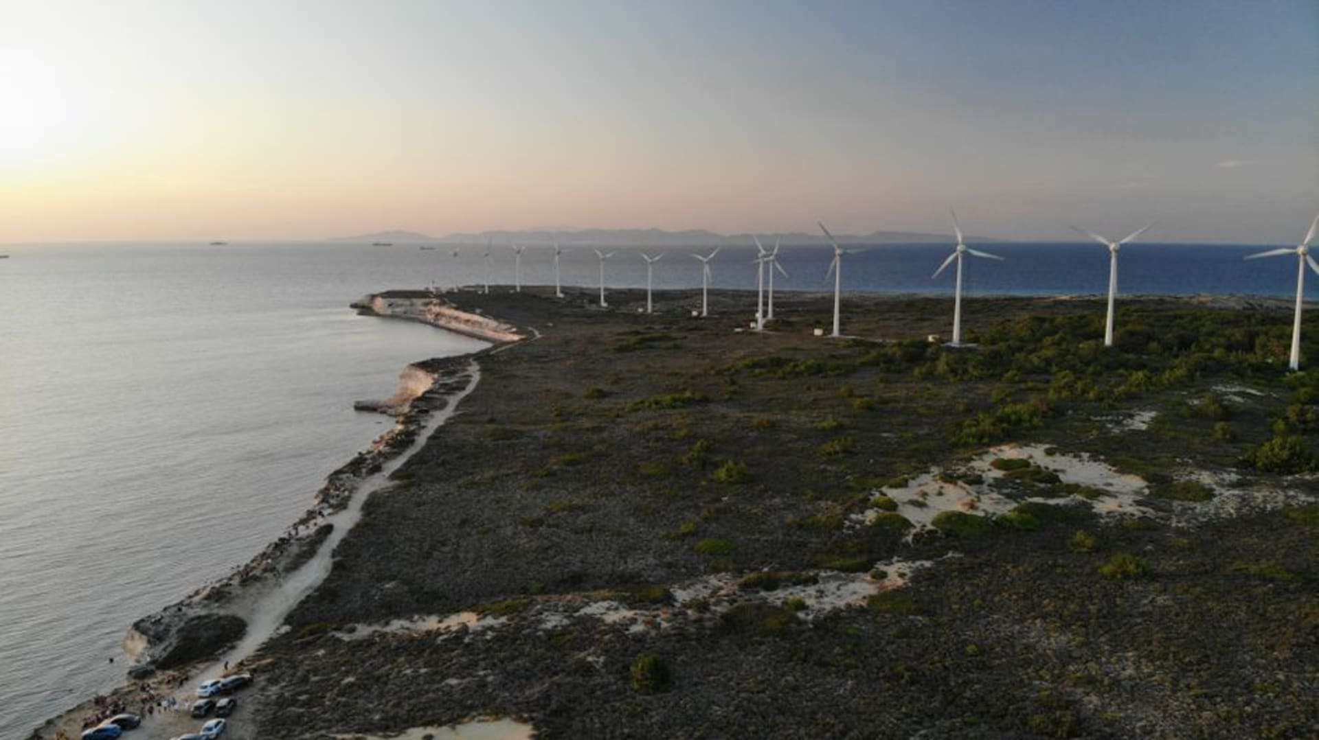 Rangées de vignes sur l'île de Bozcaada avec une rangée de moulins en pierre se découpant au sommet de la colline