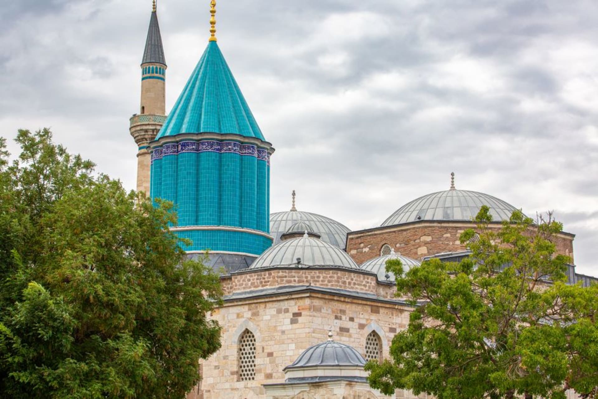 The turquoise-tiled conical dome of the Mevlana Museum in Konya against a clear sky