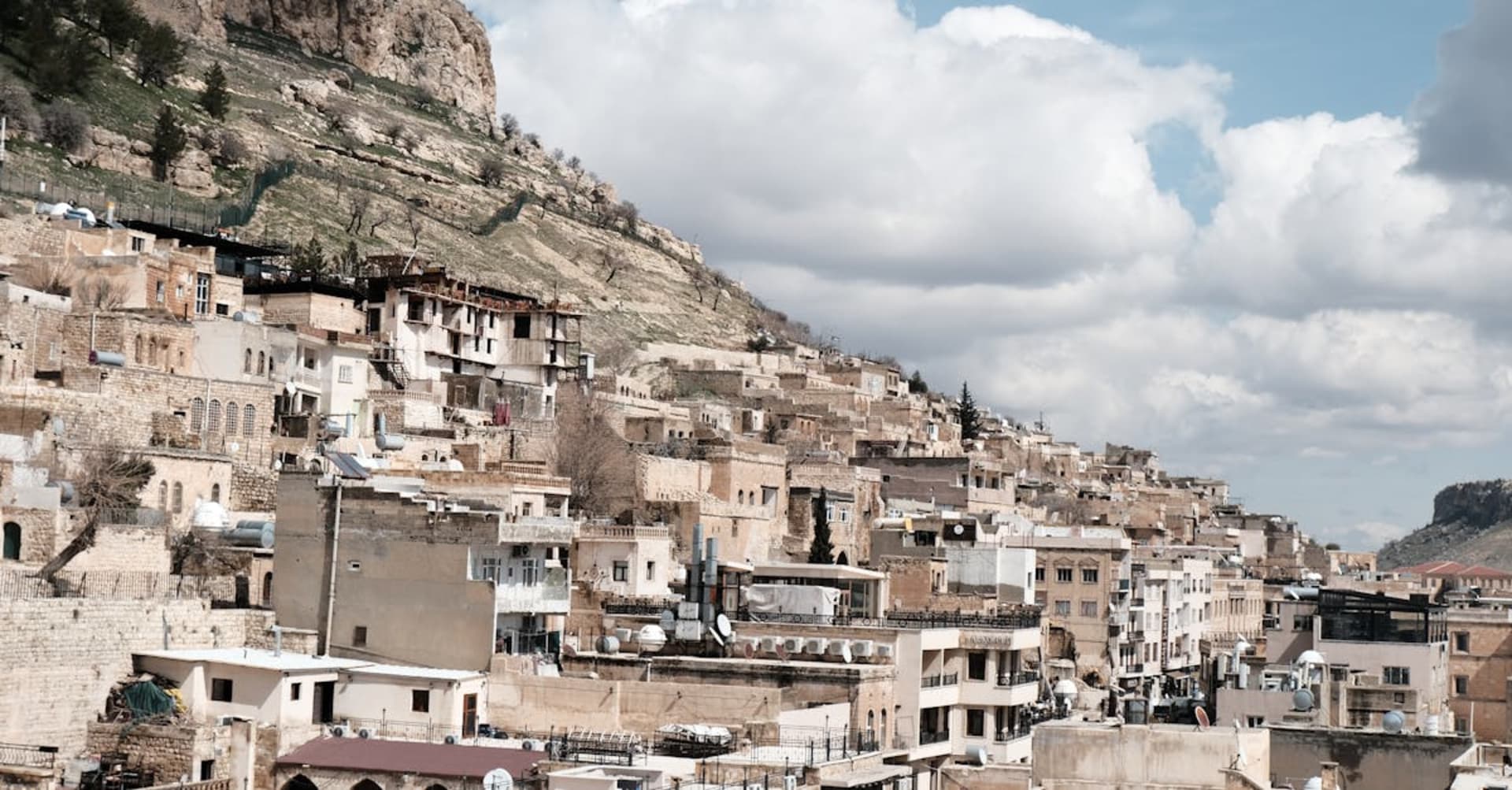 The honey-colored stone buildings of Mardin cascading down a hillside above the Mesopotamian plain