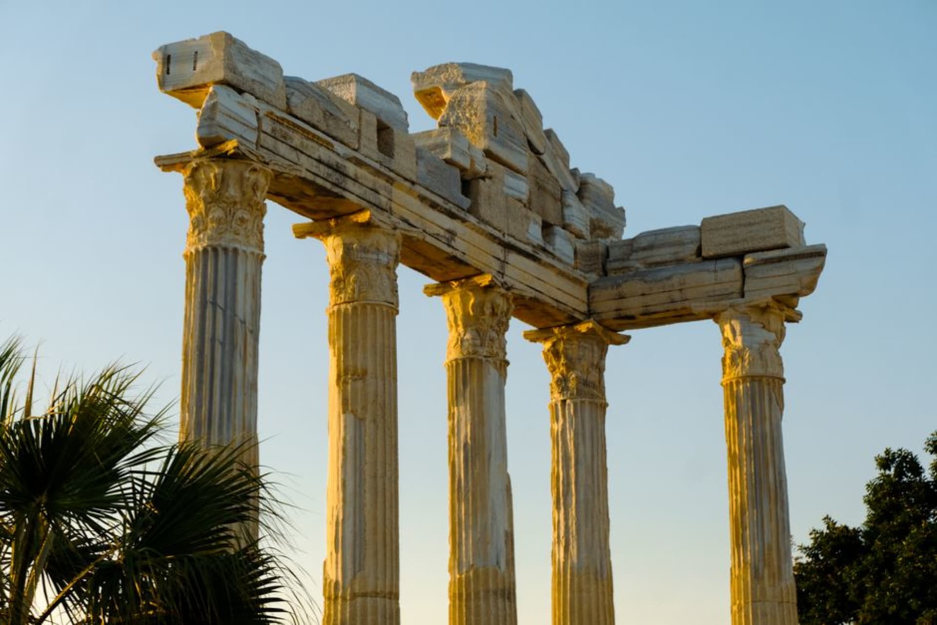 The columns of the Temple of Apollo at Side silhouetted against an orange Mediterranean sunset