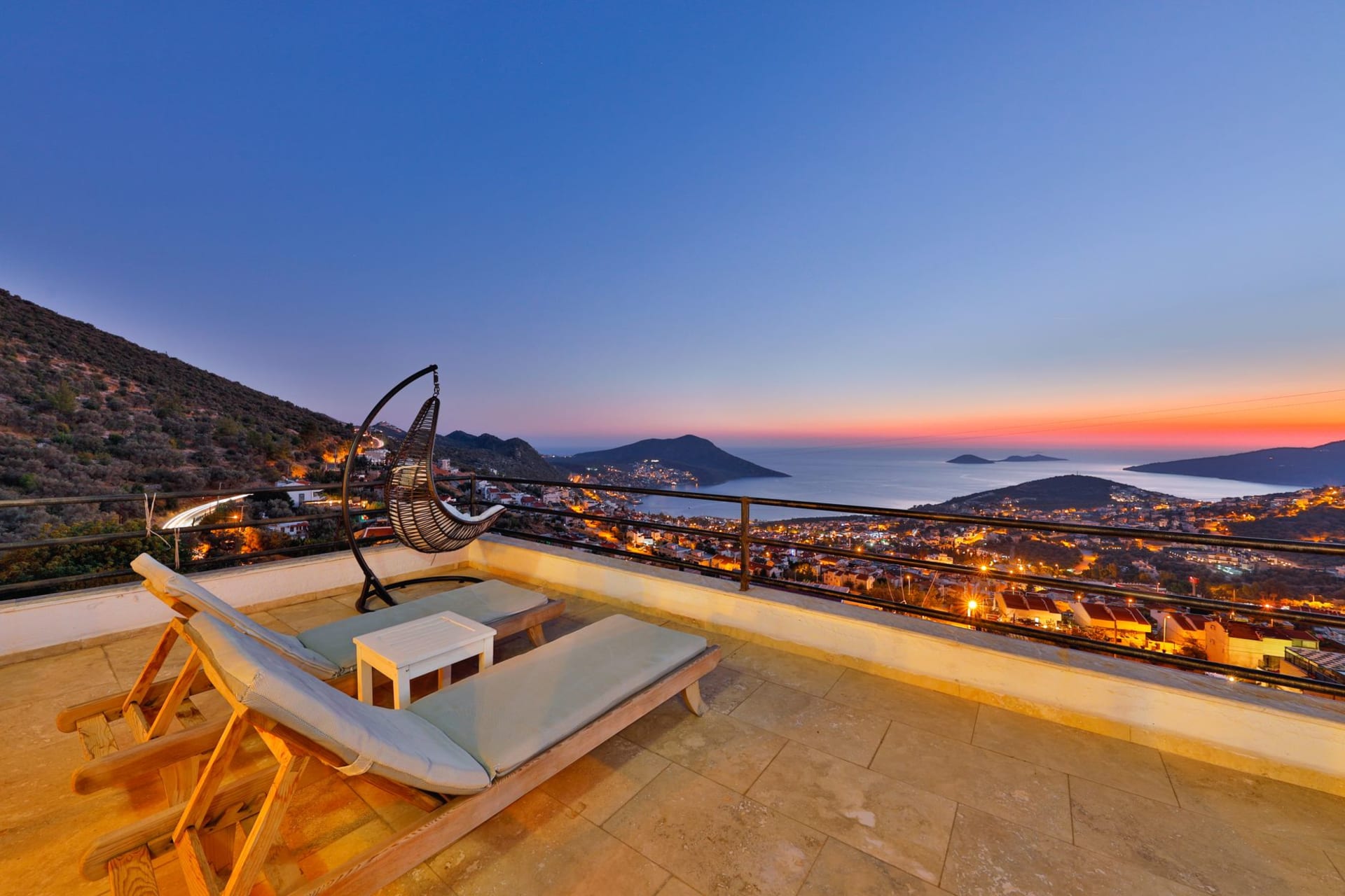 Kalkan's white cubic houses cascading down to the harbor, bougainvillea trailing over stone walls, the bay deep blue below
