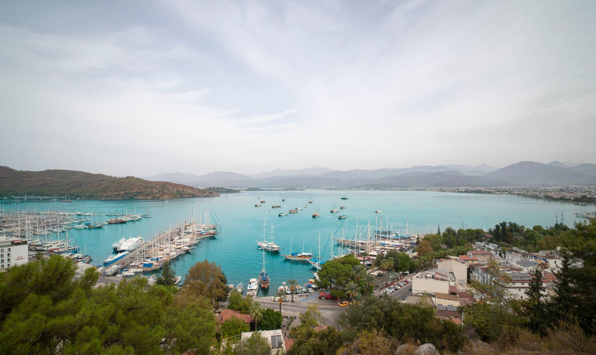 El puerto de Marmaris visto desde arriba, el castillo en su promontorio sobre una marina repleta de guletes, colinas de pinos rodeando la bahía