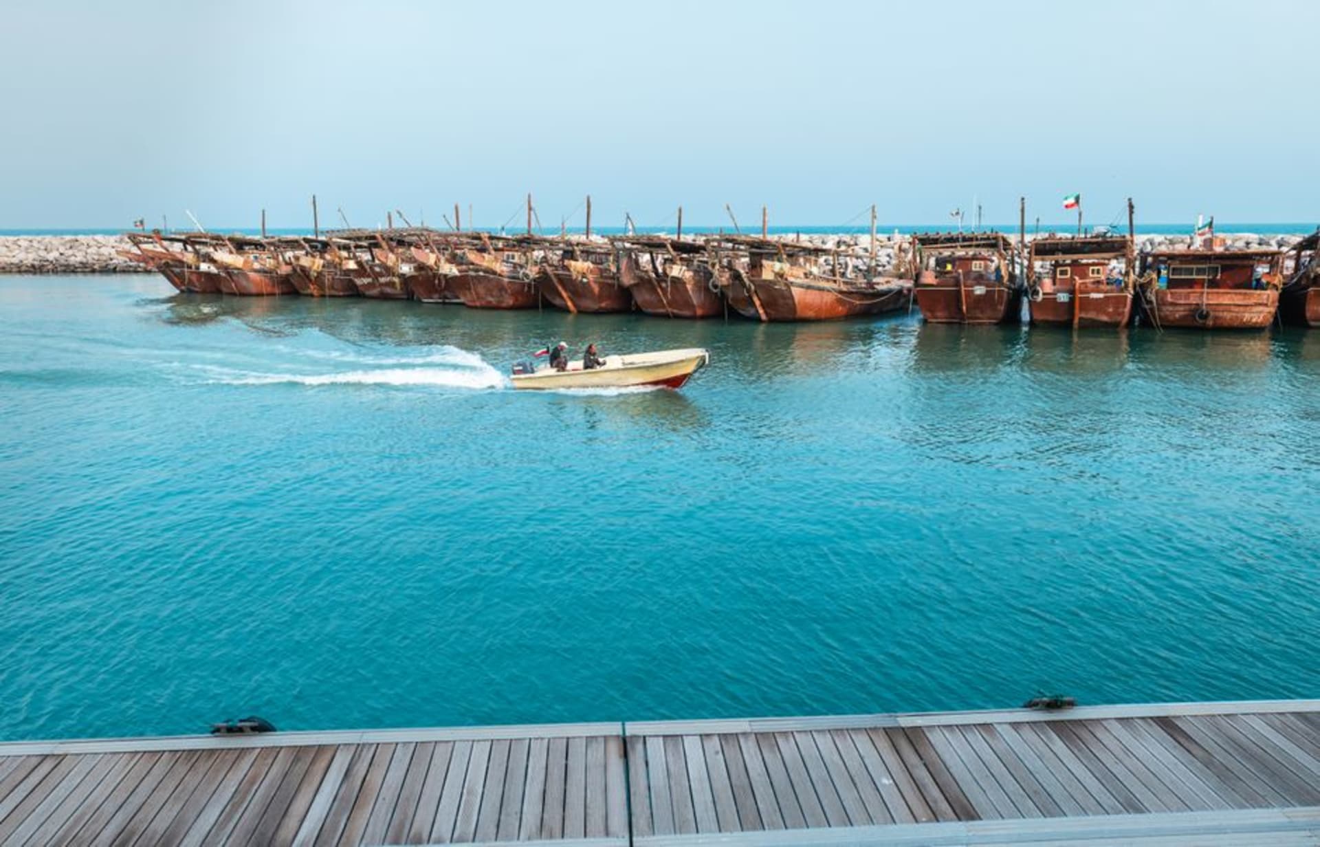 Dhow boats moored at the port of Dibba with mountains rising along the East Coast