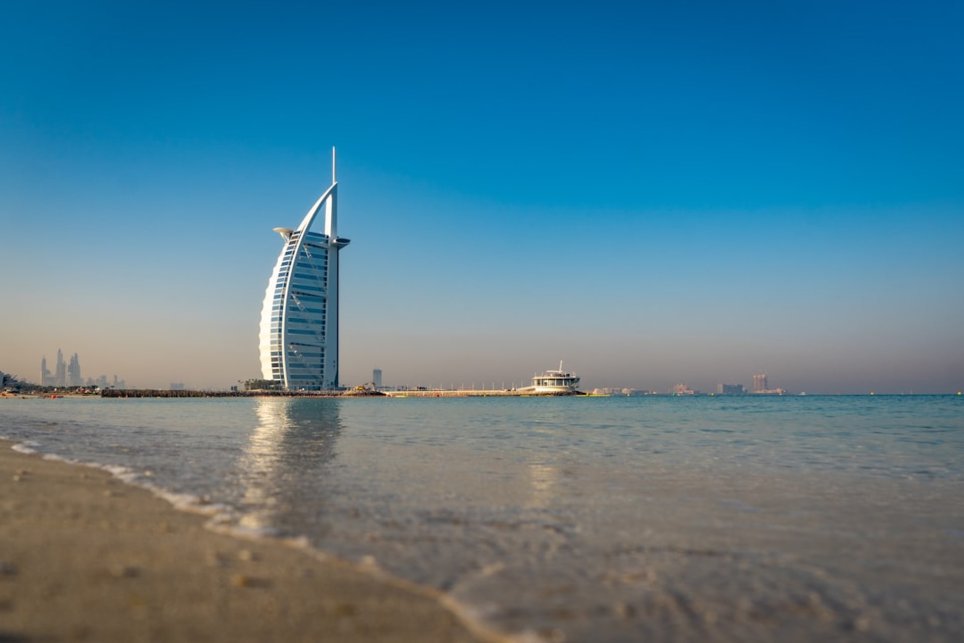 Jumeirah Beach at sunset with the Burj Al Arab visible offshore