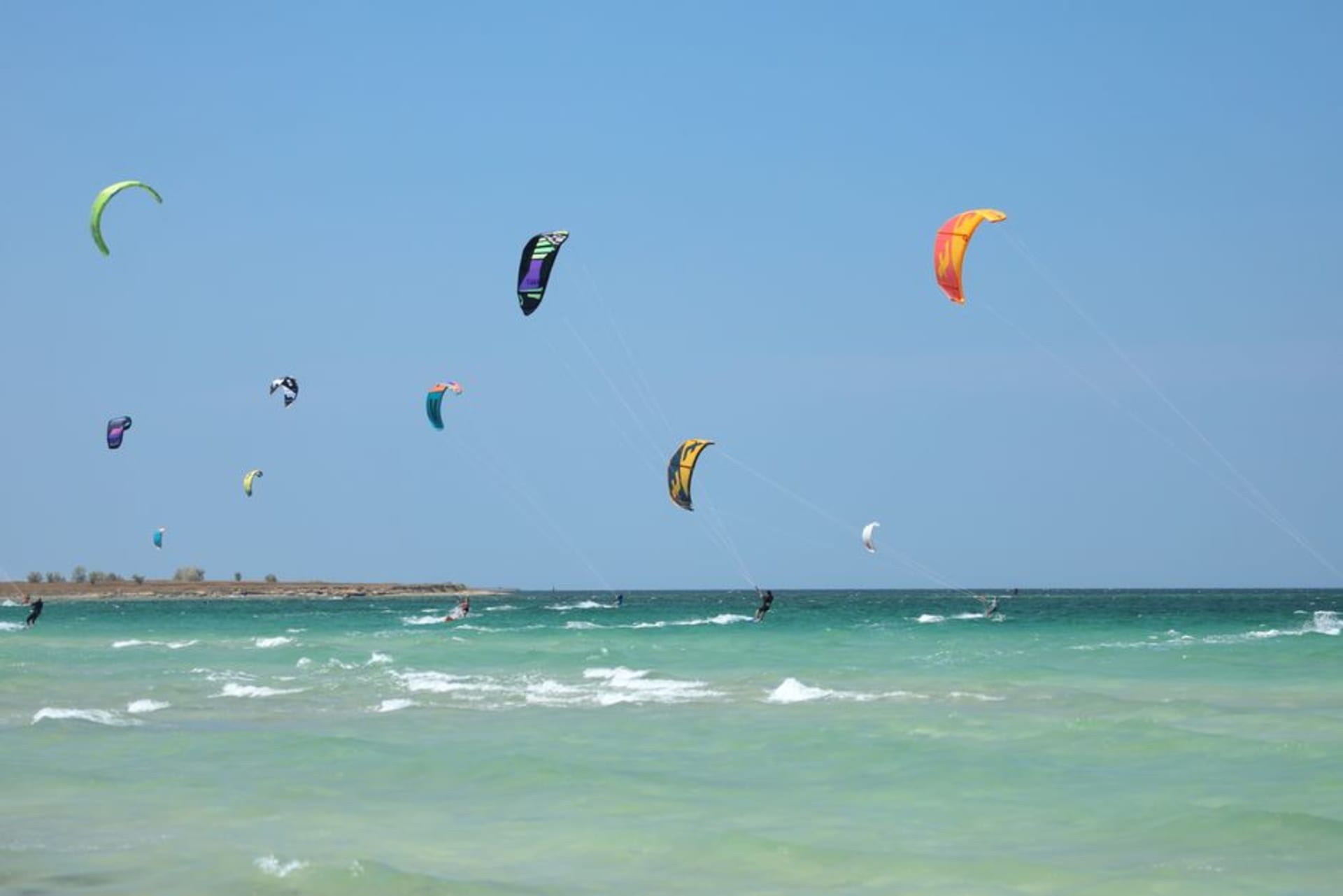 Kitesurfers with colorful kites in the sky at Kite Beach with the Burj Al Arab in the background