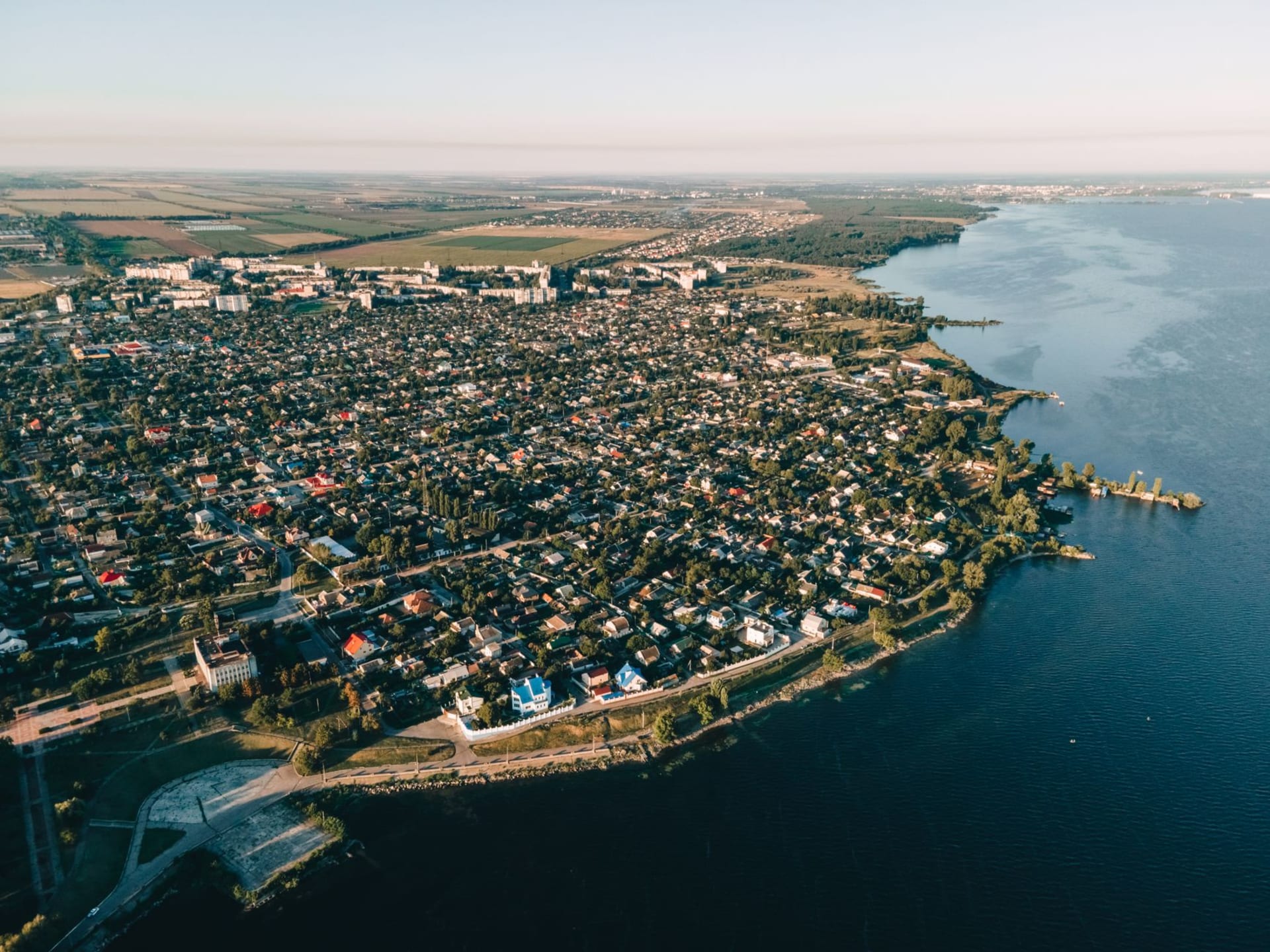 The Potemkin Stairs descending toward Odesa port at golden hour, the Black Sea glittering in the distance beyond the harbor cranes
