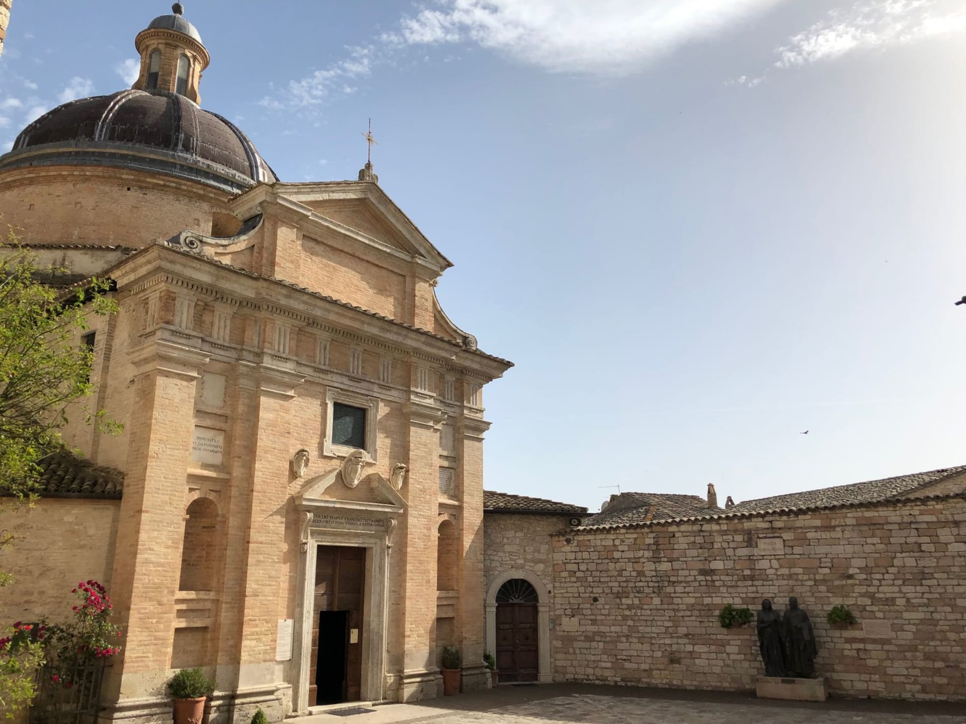 Todi's Piazza del Popolo with its three medieval palaces lined up in the afternoon light, the Duomo steps empty in the golden hour