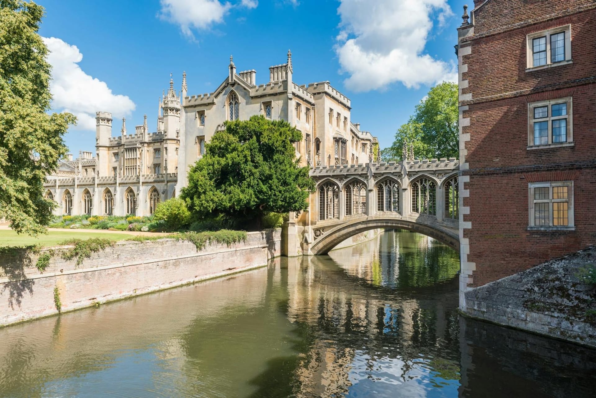 Punting boats gliding beneath the stone bridges of the Cambridge Backs, with the Gothic spires of King's College Chapel rising above willow-draped riverbanks in soft afternoon light.