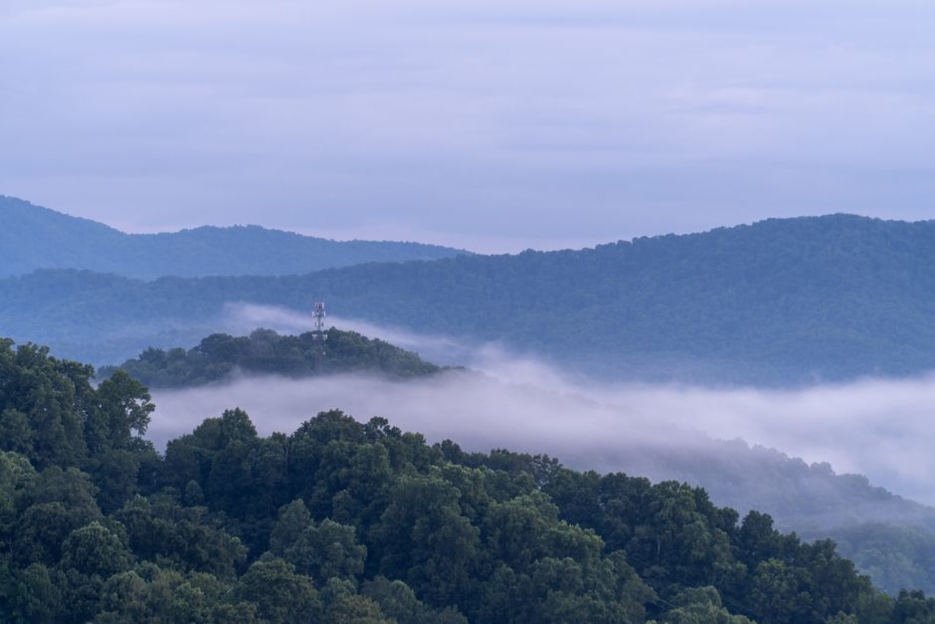 Downtown Asheville rooftops with the misty Blue Ridge Mountains beyond