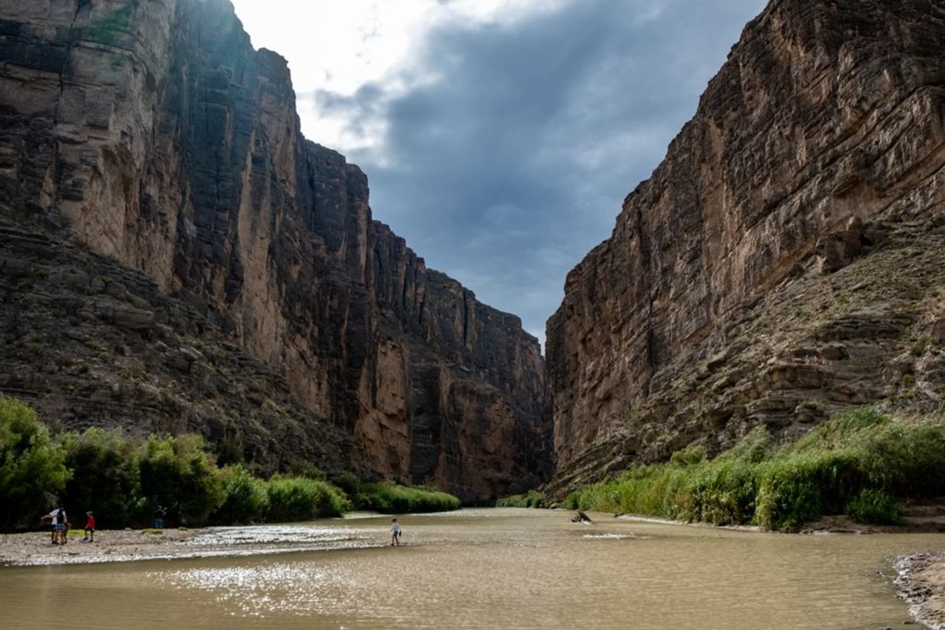 The Rio Grande winding through the towering walls of Santa Elena Canyon at Big Bend, desert stretching to distant mountains