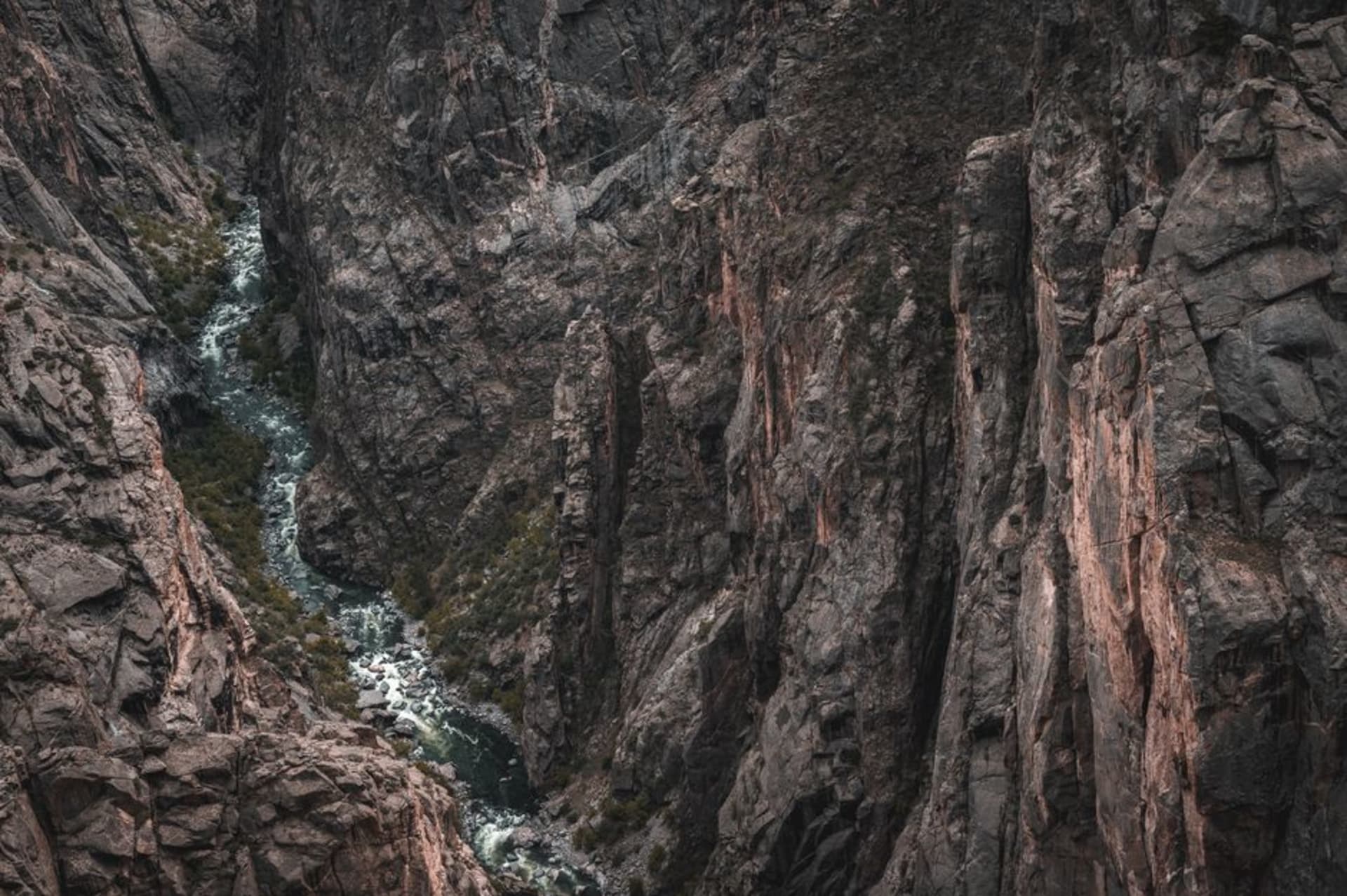 Sheer dark canyon walls plunging to a thin river far below