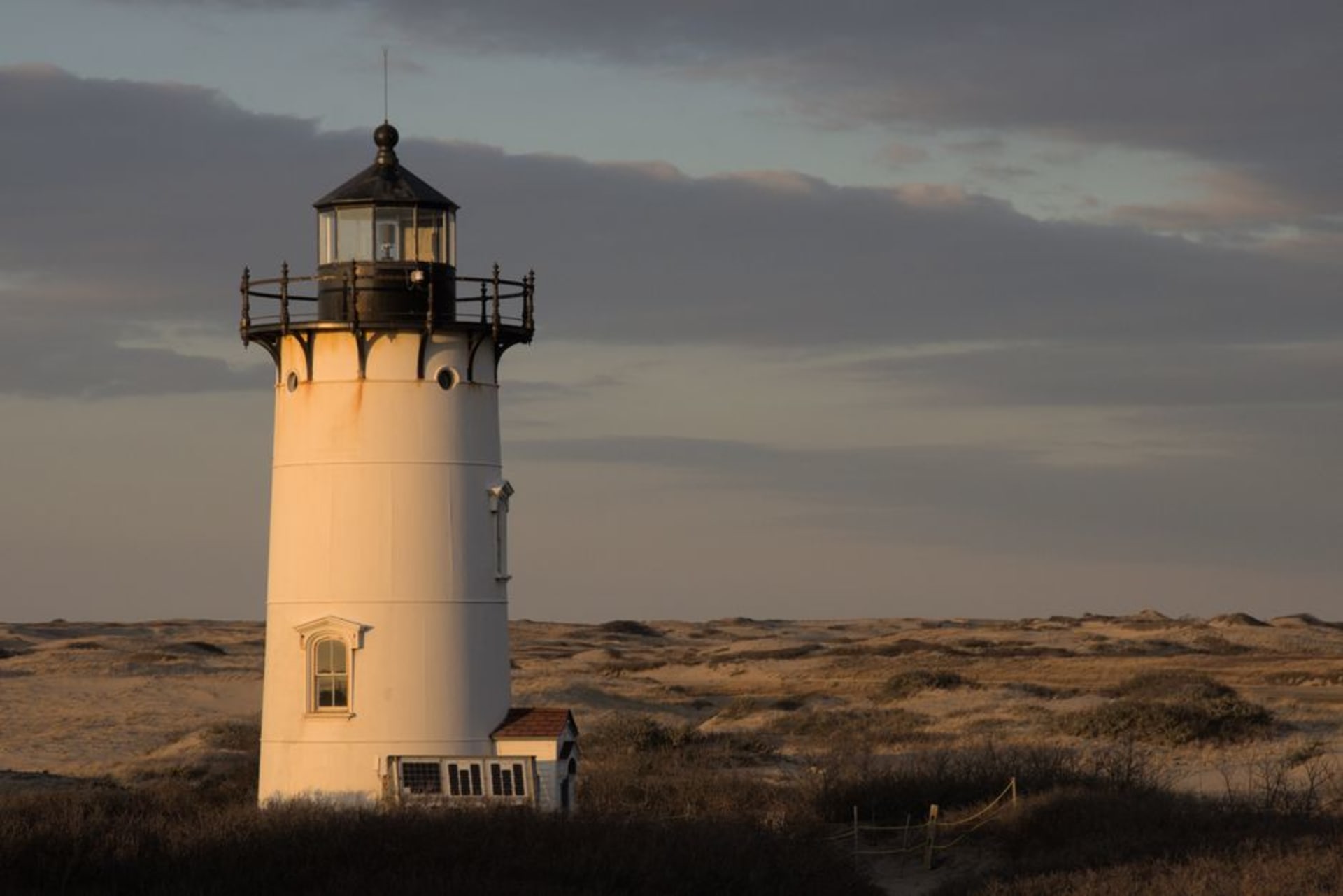 Nauset Light standing red-and-white above the dune grass at the edge of the Atlantic