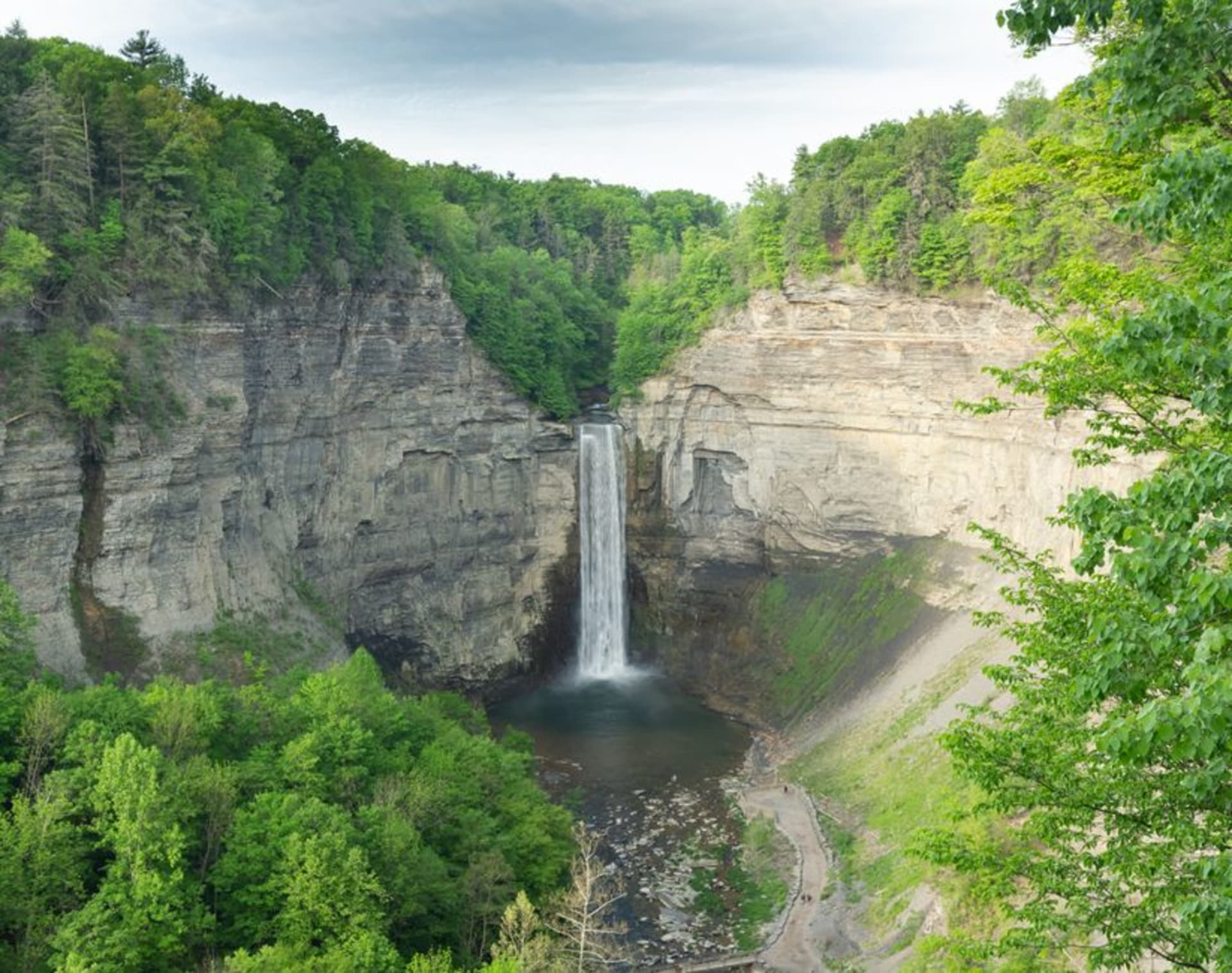 A waterfall plunging through a stone gorge at Watkins Glen, ferns clinging to the walls