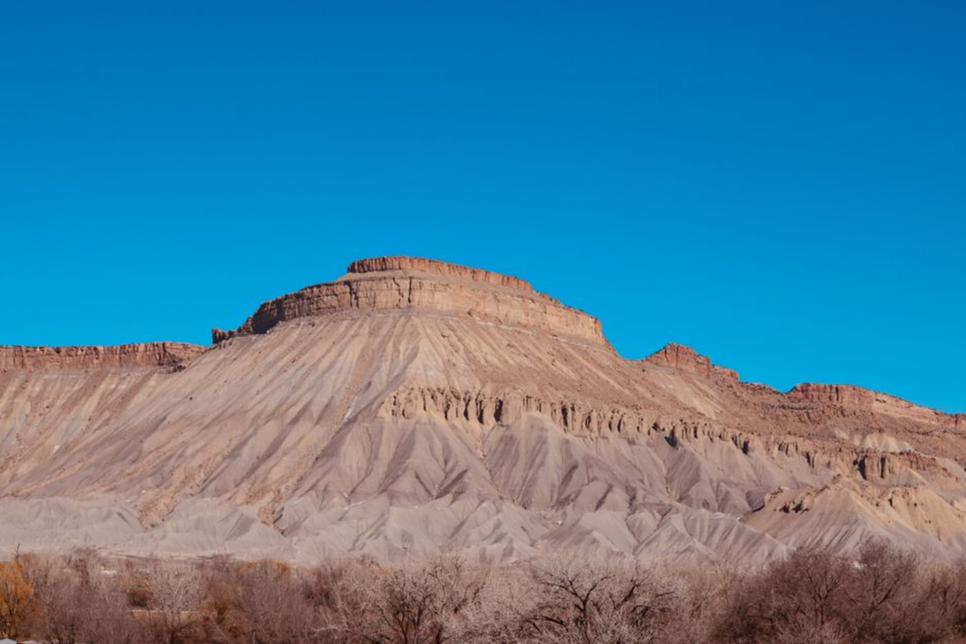 The sheer limestone face of El Capitan and Guadalupe Peak rising from the Chihuahuan Desert in West Texas under a wide blue sky