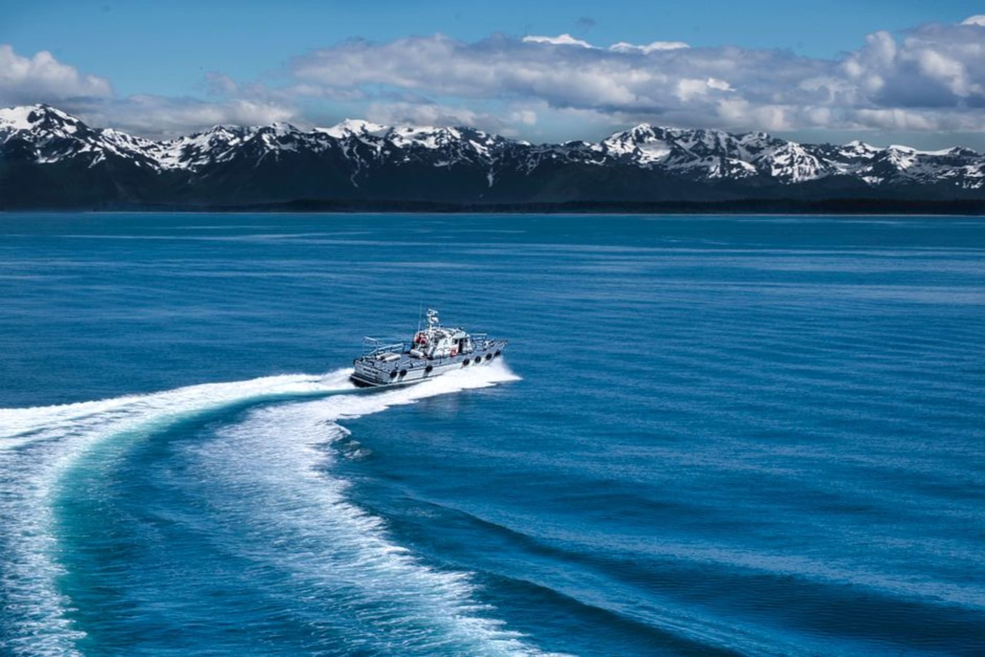 The long gravel Homer Spit reaching into Kachemak Bay with snow-covered mountains and glaciers rising across the water
