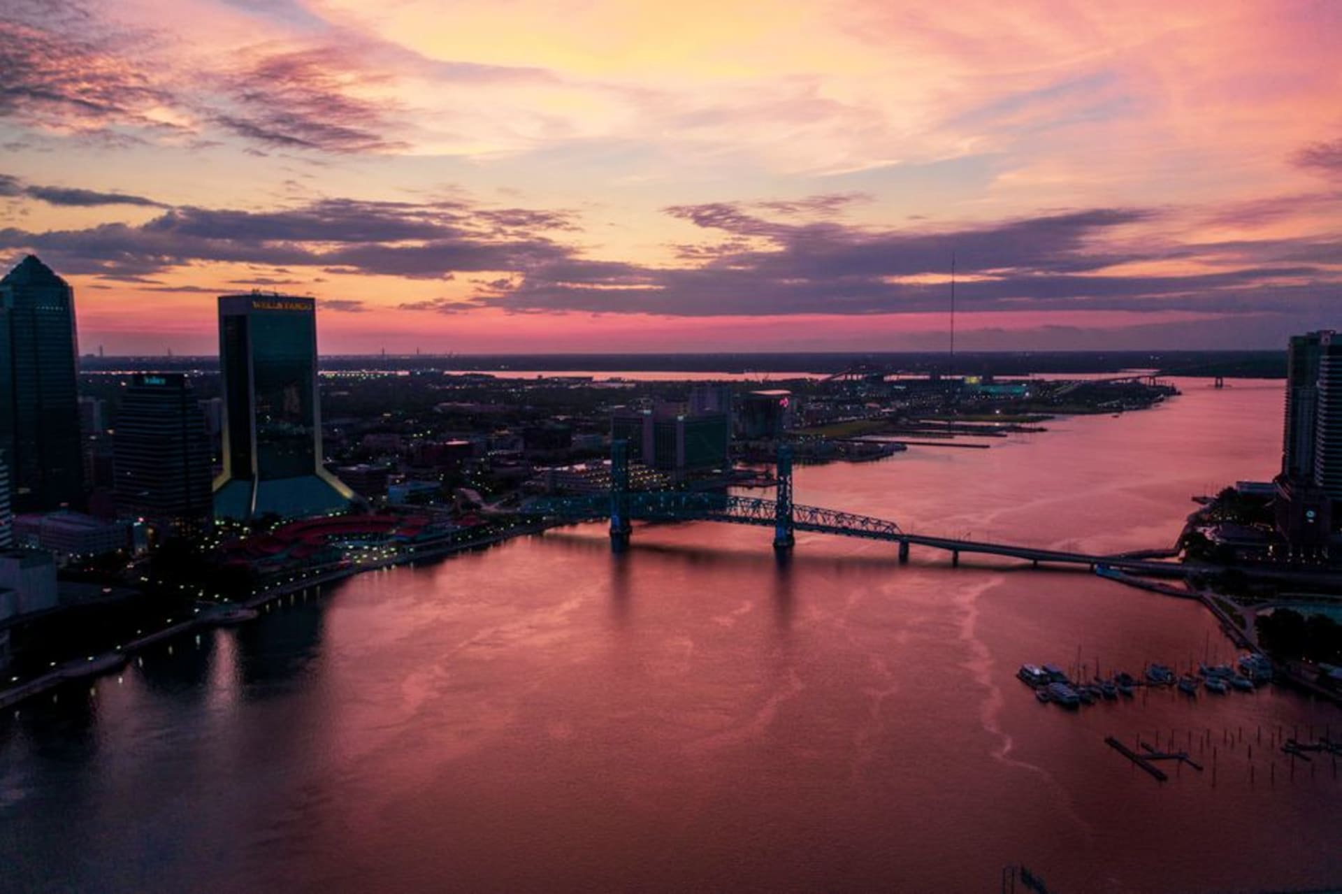 The St. Johns River curving past the Jacksonville skyline at dusk with lit bridges