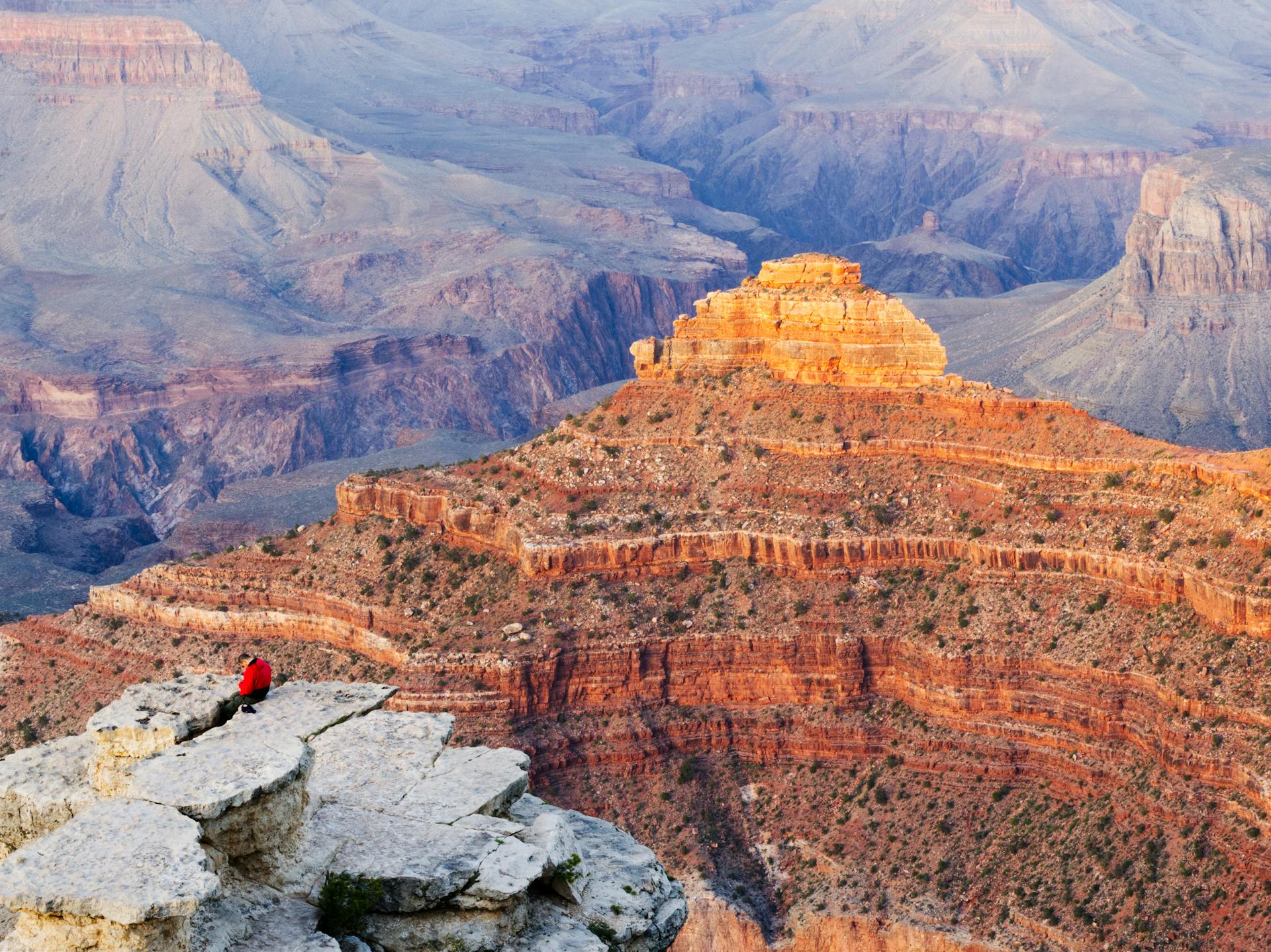 Sweeping view of a desert canyon at golden hour with layered red rock formations