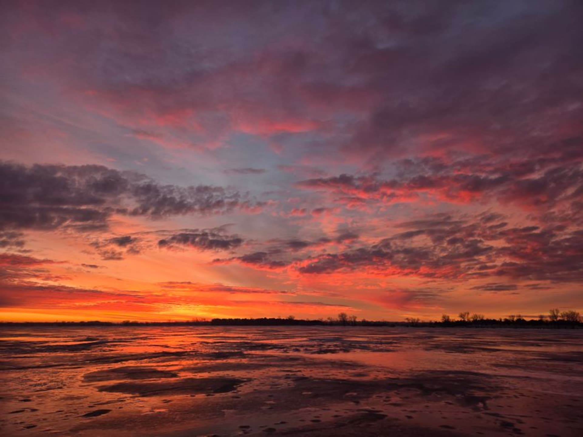 The Missouri River at dusk near Williston, North Dakota with oil field flares in the distance