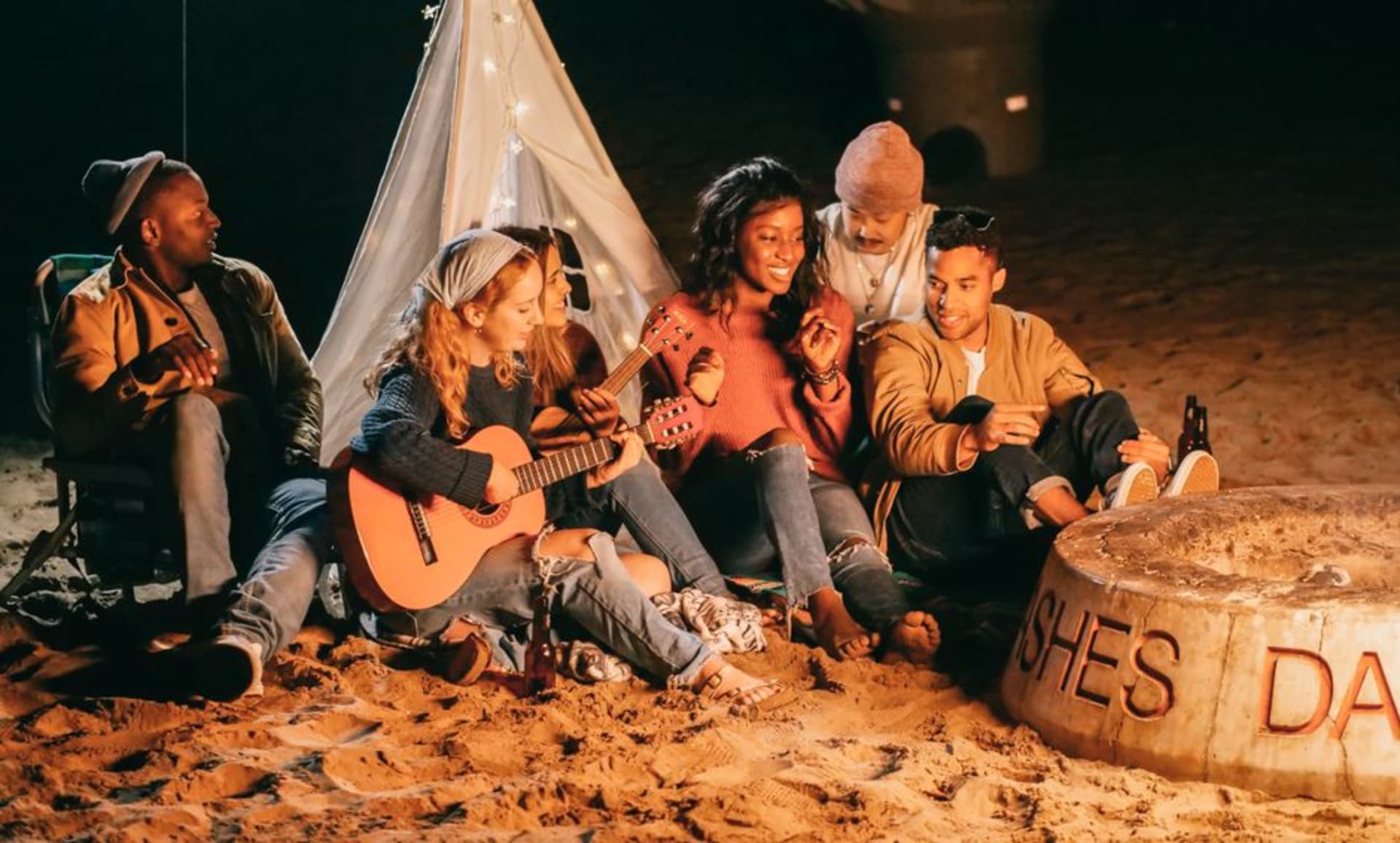 Musicians playing acoustic guitars around a campfire at the Walnut Valley Festival grounds near Winfield, Kansas