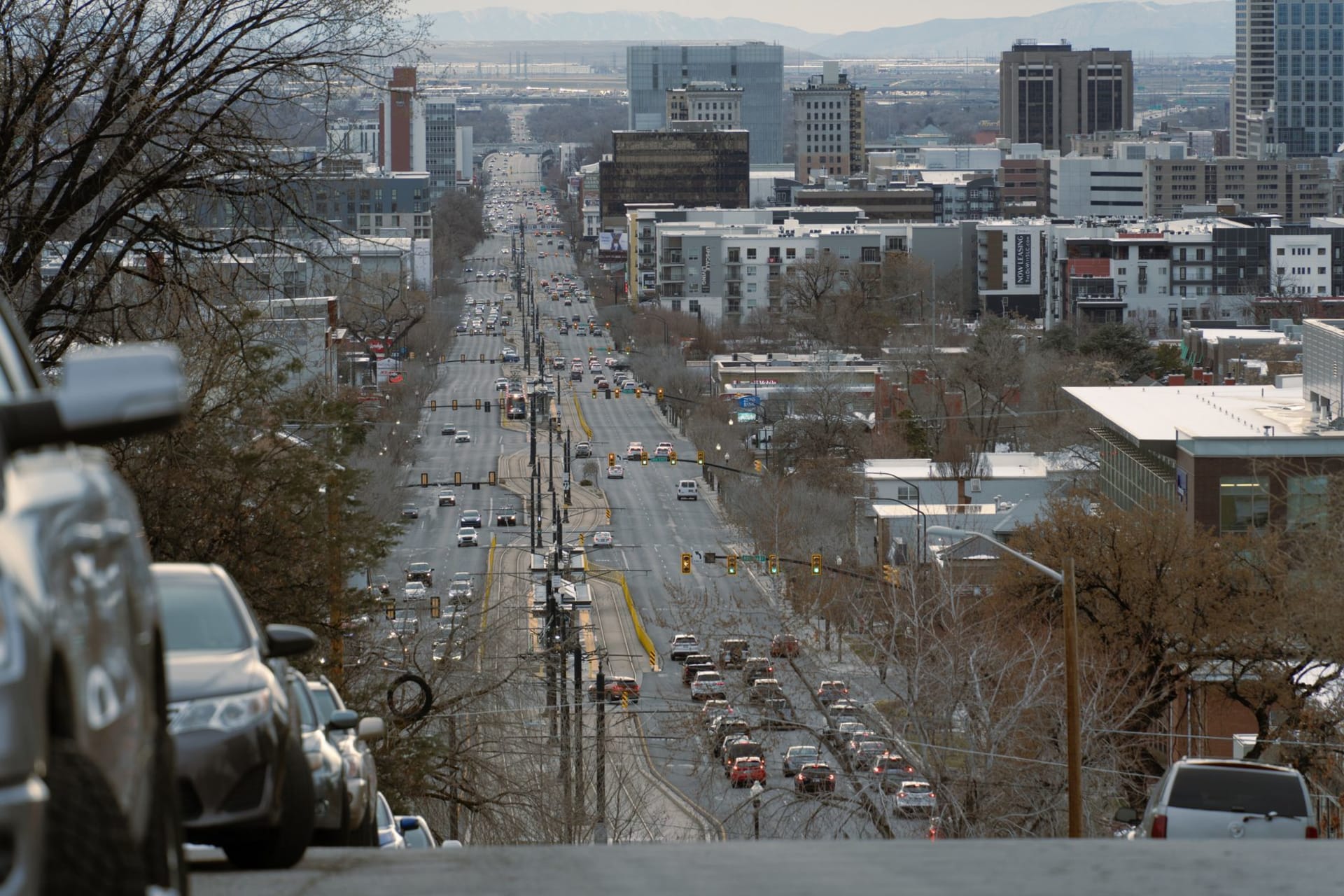 Park City's historic Main Street in winter with Victorian-era storefronts lit up and snow on the roof lines, ski mountain visible above the town