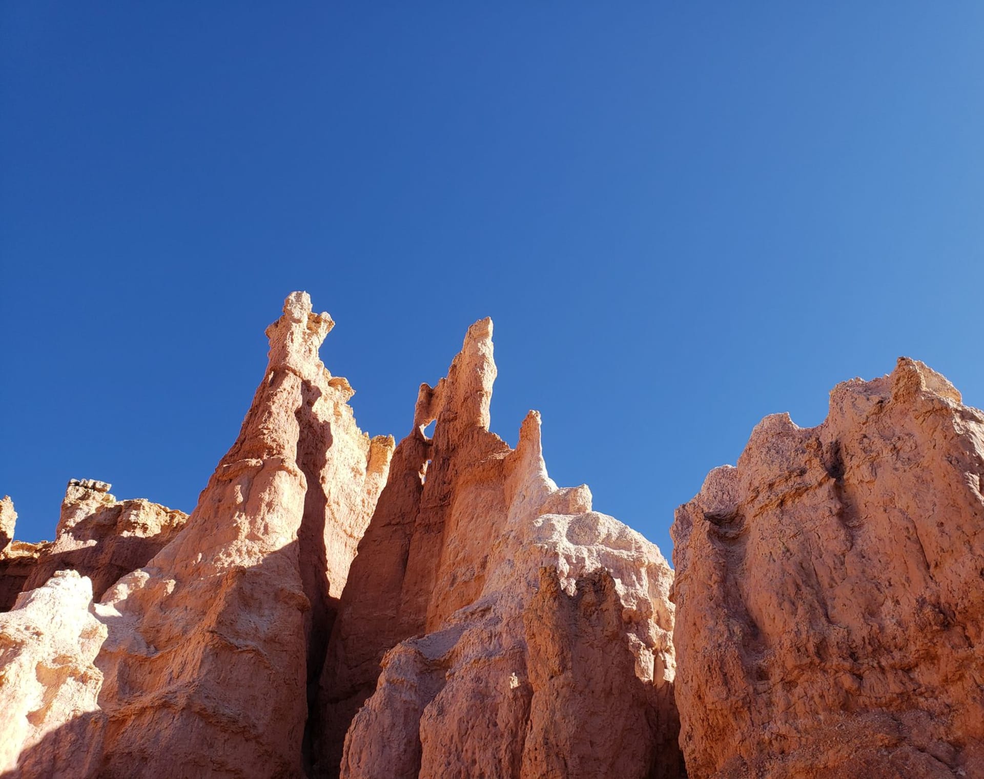 Towering red sandstone formations rising into a deep blue sky in Utah's canyon country