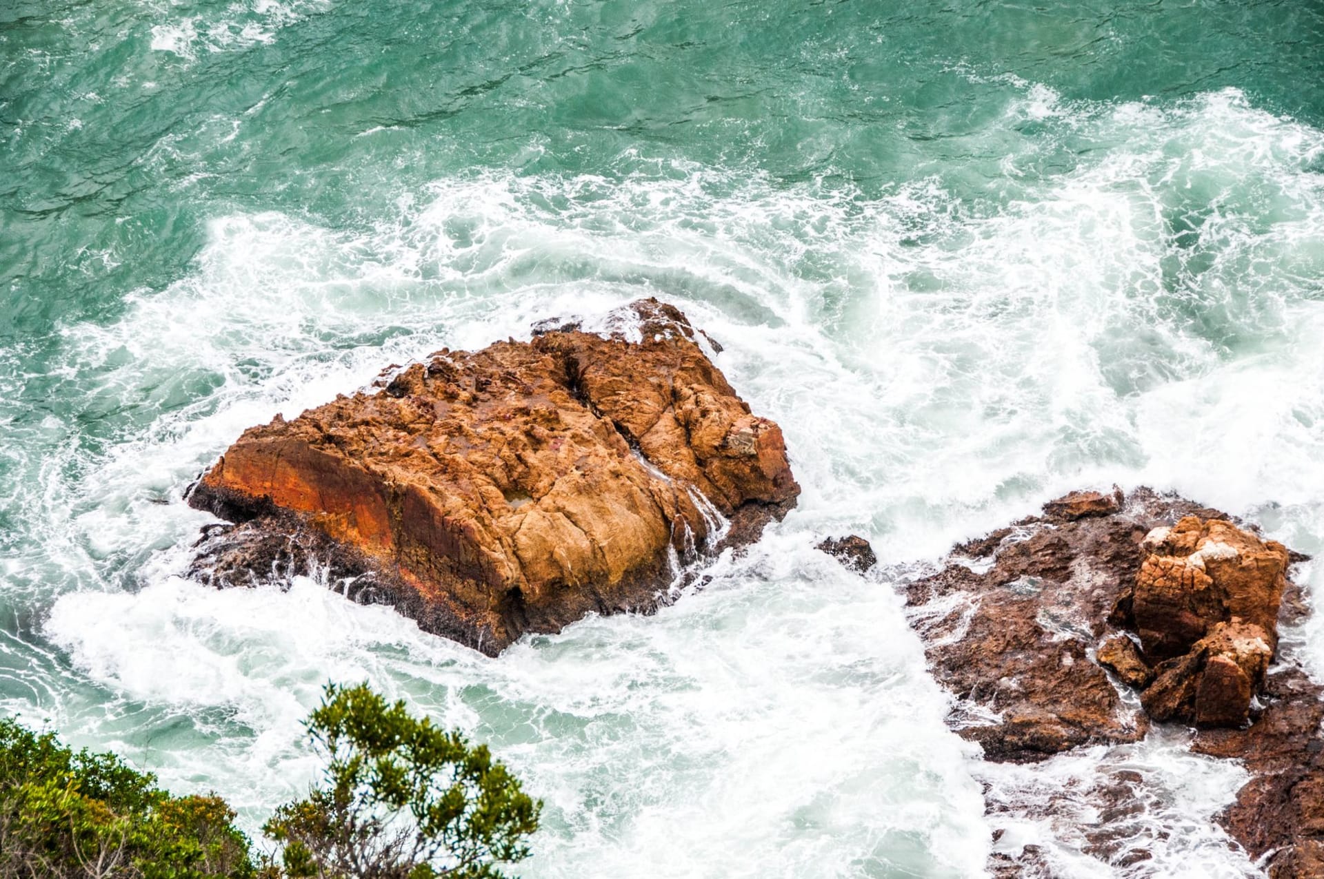 The churning Boiling Pot plunge pool viewed from above at the bottom of Victoria Falls gorge, with spray and dark basalt walls