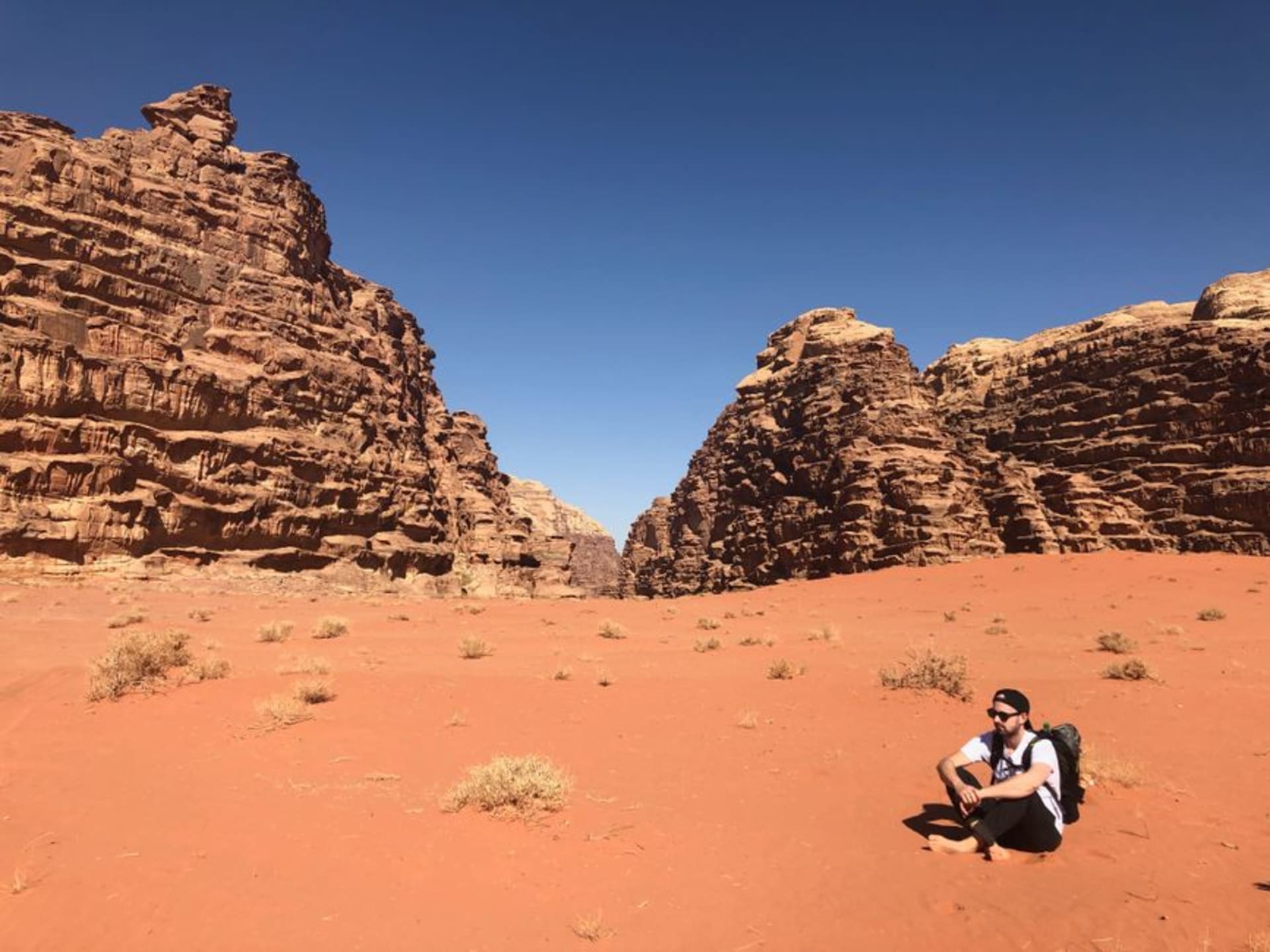 Luz solar iluminando las paredes de arenisca roja y dorada del Cañón de Barrah en Wadi Rum