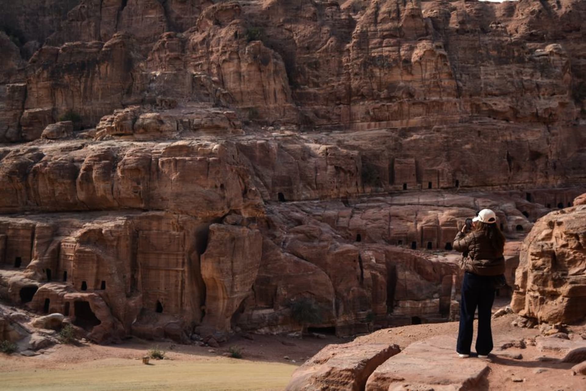 Sandstone columns of the Nabataean Temple of Allat standing against the cliffs of Jebel Rum at sunset