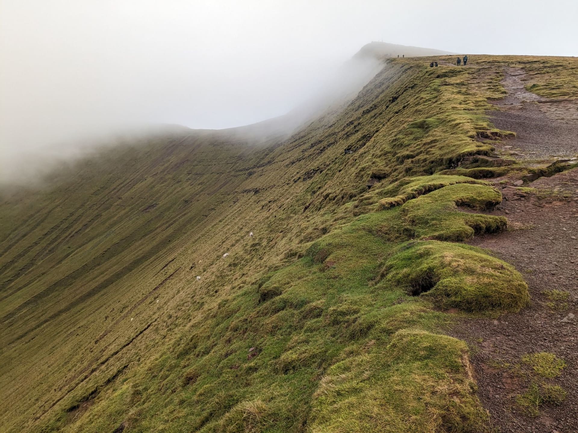 The flat summit of Pen y Fan seen across the Neuadd reservoir at dusk, last light catching the red sandstone escarpment