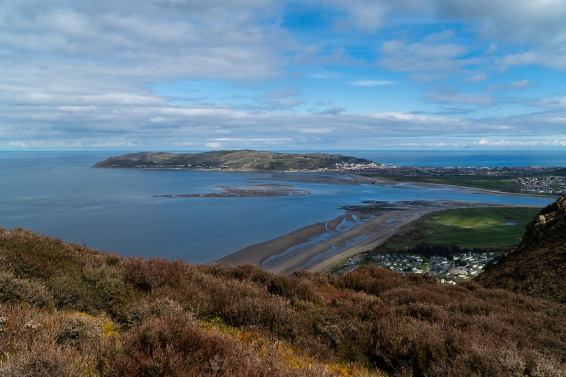 Conwy Castle's eight drum towers reflected in the estuary at high tide, mountains of Snowdonia rising behind