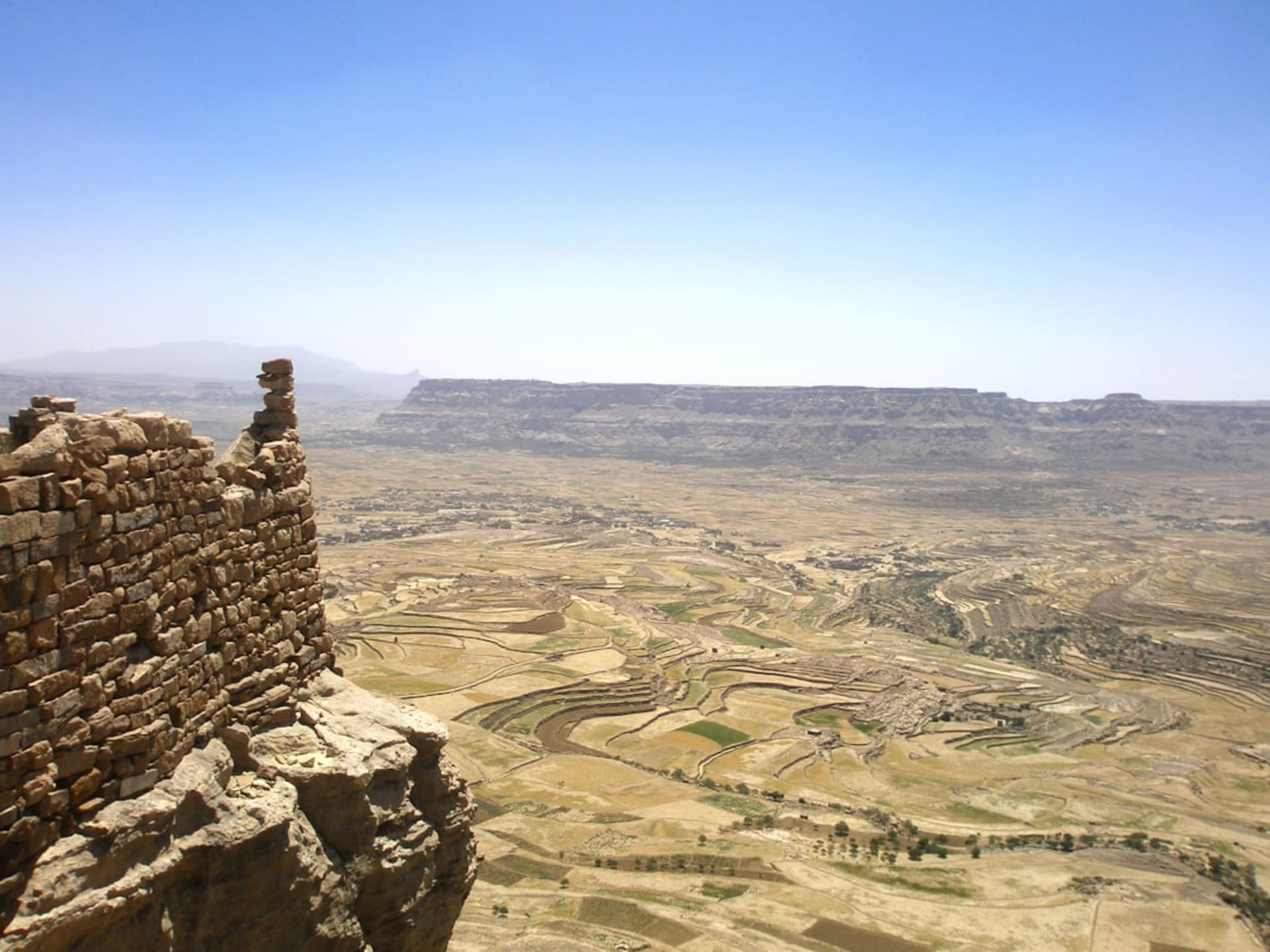 The ancient columns of the Bar'an Temple at Marib rising against a desert sky at sunrise, sand dunes in the background