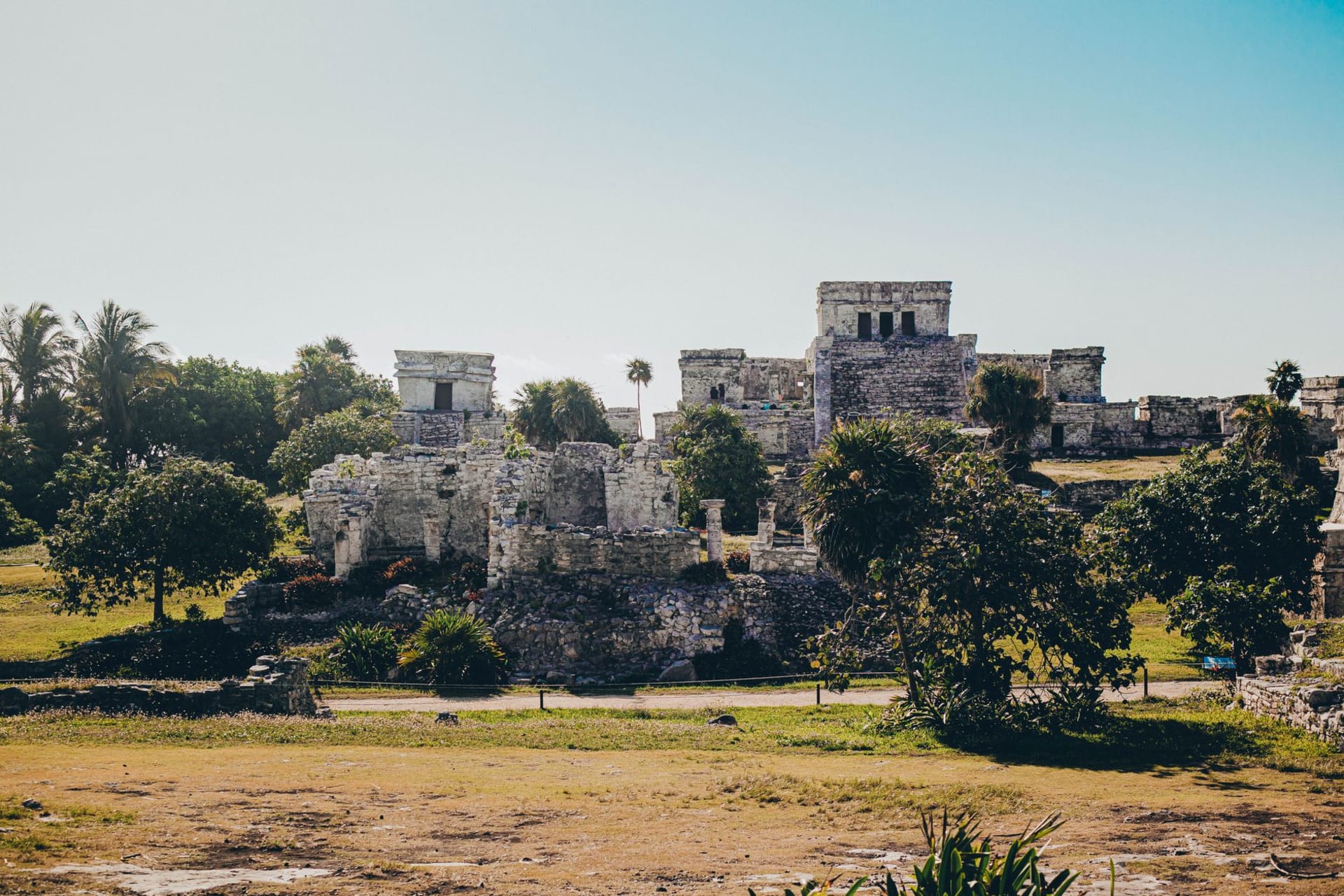 The El Castillo temple at Tulum ruins perched on limestone cliffs above turquoise Caribbean water, morning light, no crowds