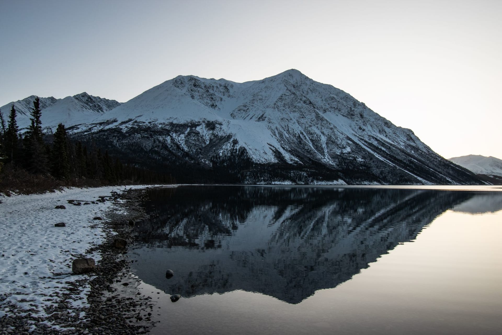 Kluane's St. Elias Mountains reflected in the still surface of Kluane Lake at golden hour, the peaks carrying glaciers down their flanks