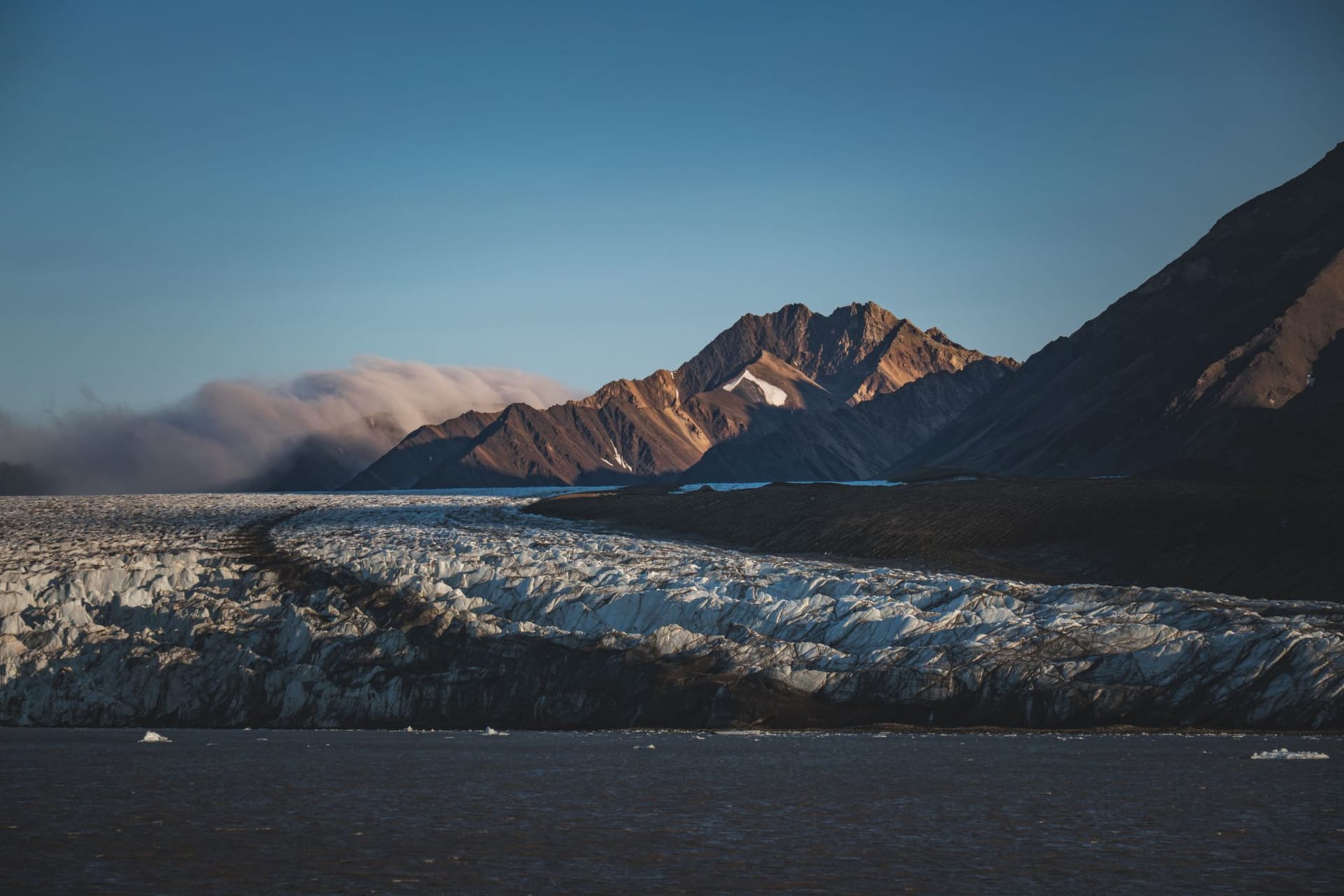 The granite spires of Tombstone Mountain rising above autumn tundra blazing in orange and red, the Dempster Highway disappearing into the valley below