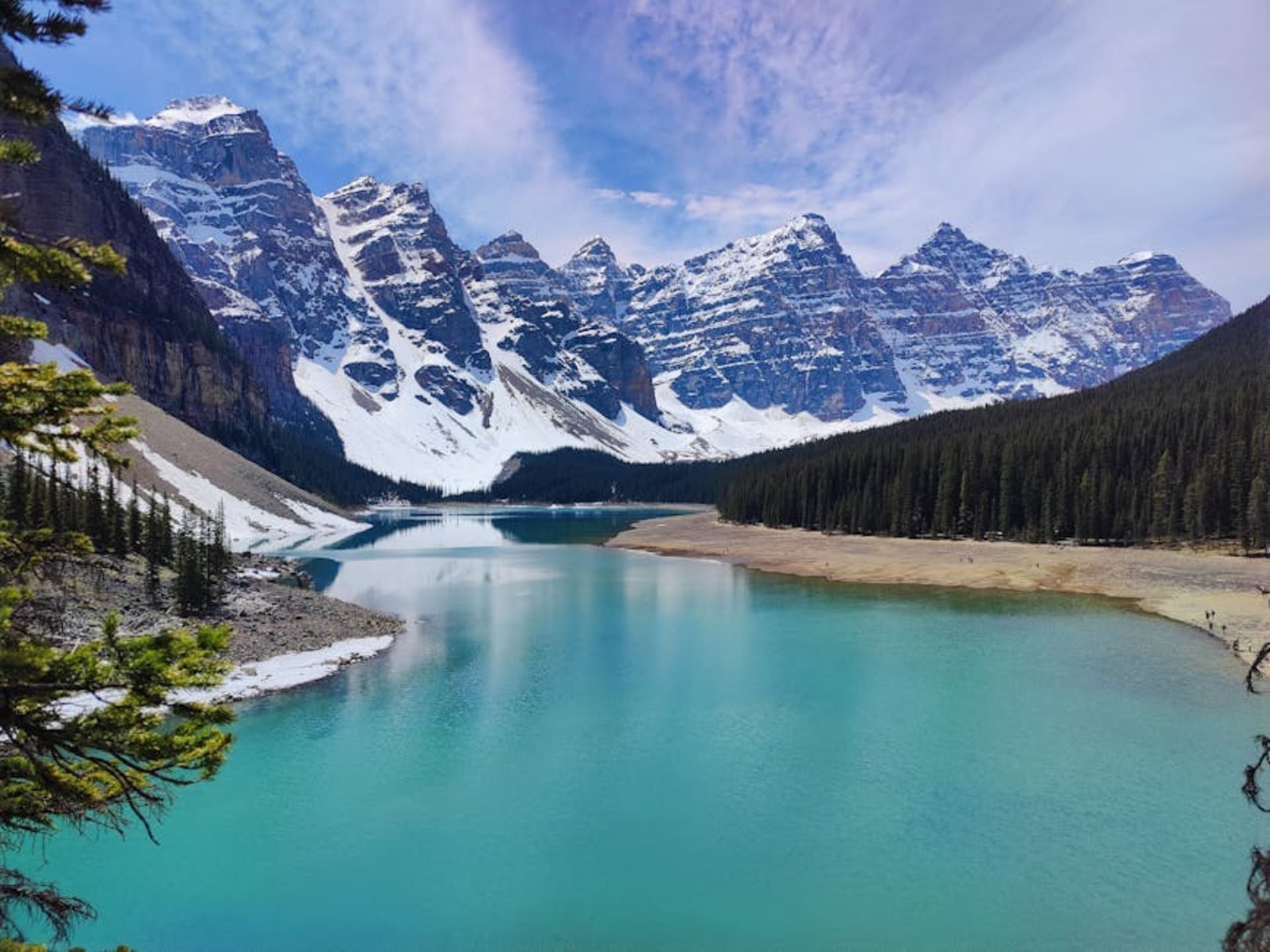 Turquoise glacial lake surrounded by towering Rocky Mountain peaks