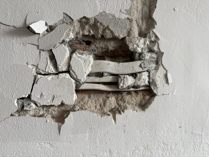 Skuta ściana z odsłoniętymi przewodami podczas prac wyburzeniowych
