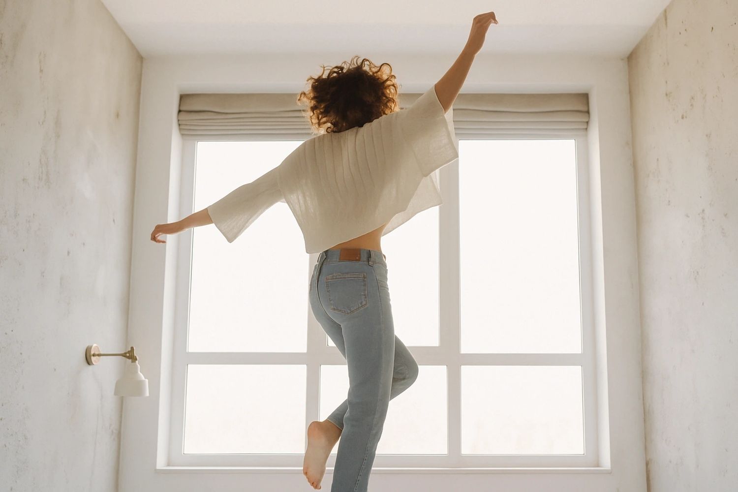 Woman joyfully dancing in a bright room