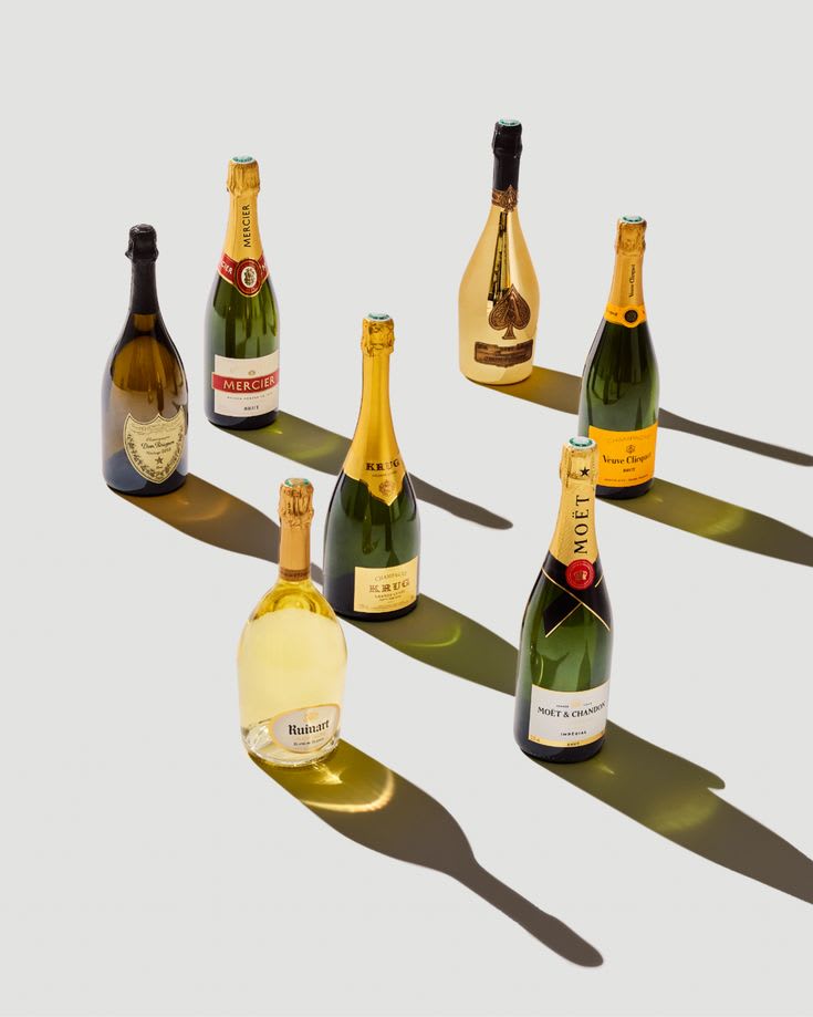 Assorted premium Champagne bottles including Moët, Veuve Clicquot, and Ruinart on a styled drinks table