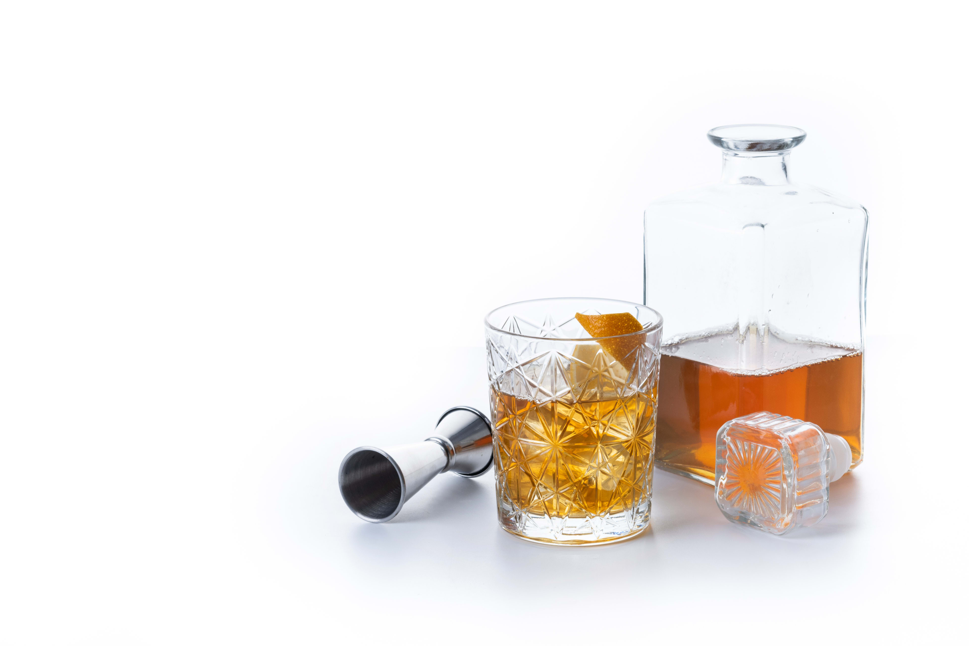 Three glasses of Scotch whisky representing Speyside, Highland, and Islay regions on a wooden bar