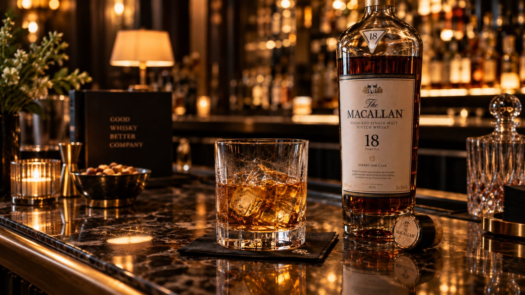 Close-up of a glass of amber whisky on ice beside an open bottle of Scotch on a bar counter