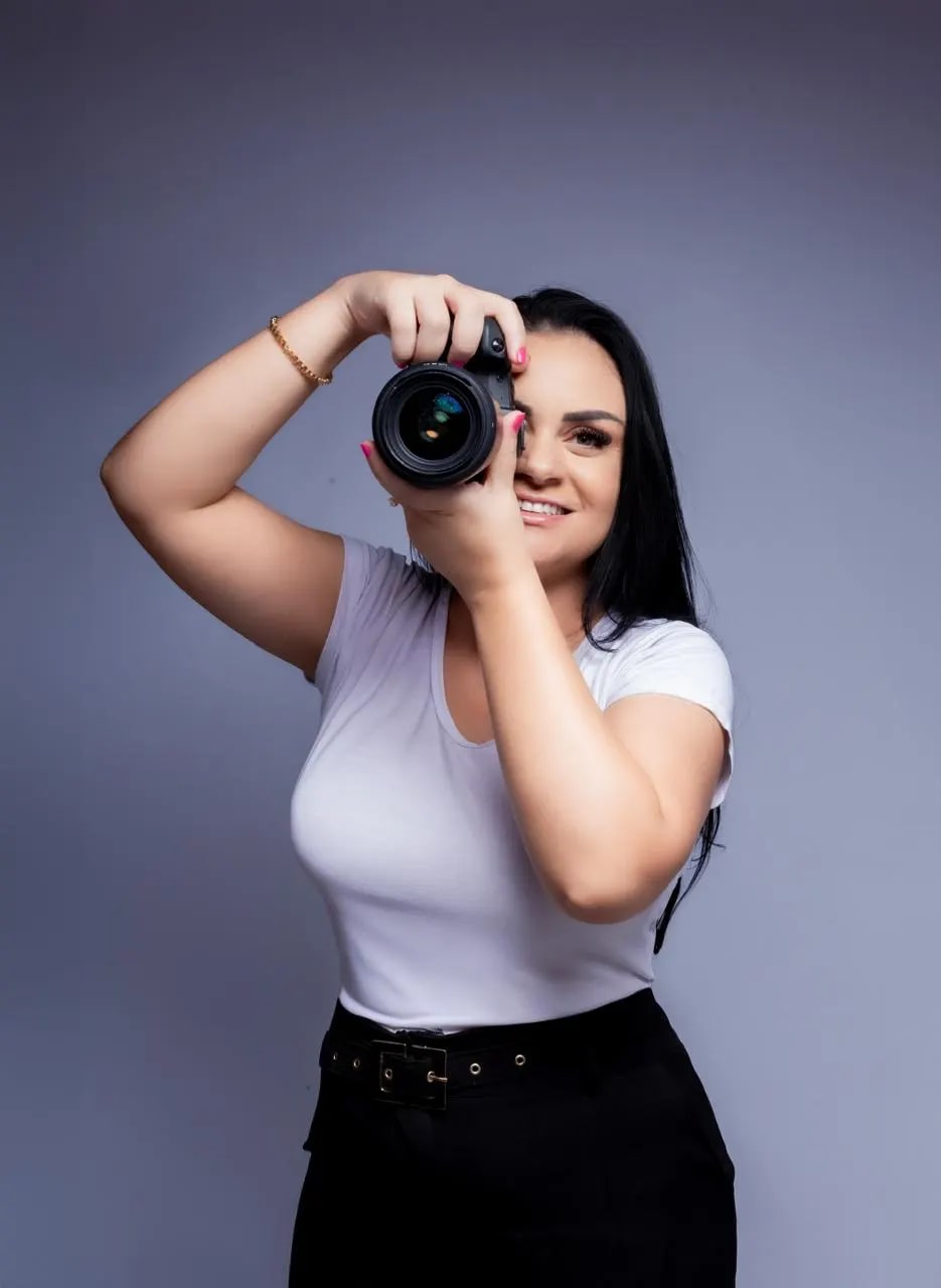 Denise Galvão segurando sua câmera durante um ensaio