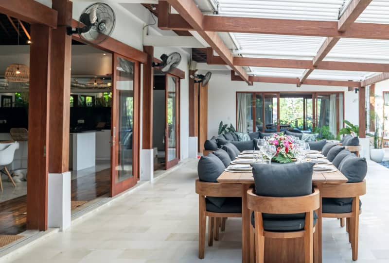 Large 12-seater solid timber dining table in the heart of the open-air pavilion
