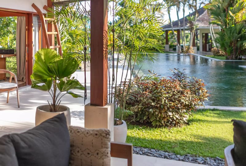 View from the villa terrace overlooking the swimming pool and lush tropical greenery
