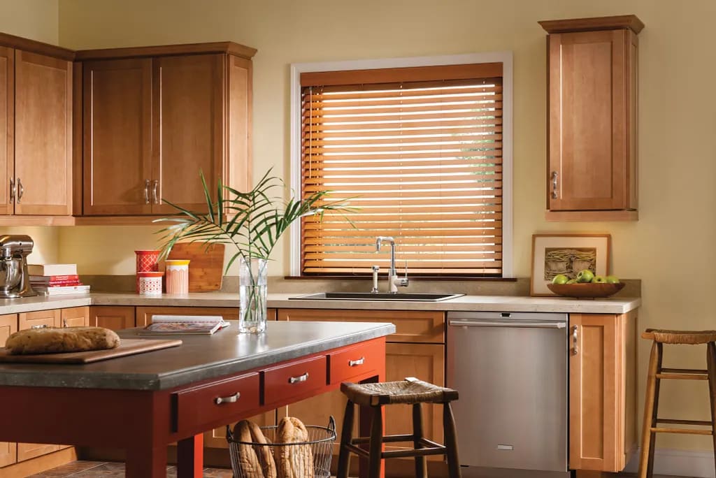 Wood and faux wood blinds with wide slats in a bright room