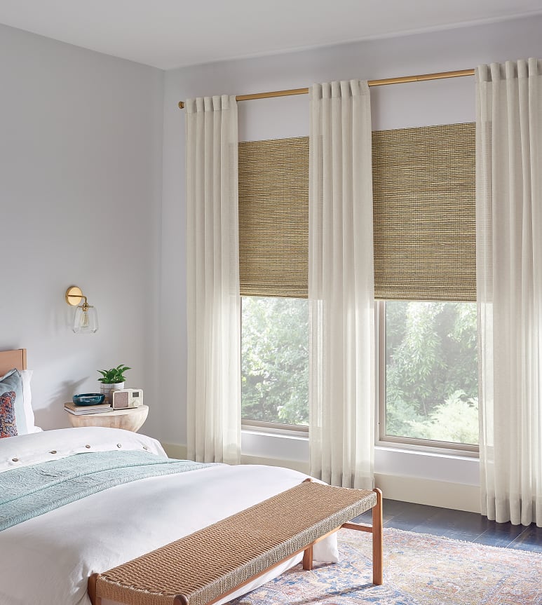 Tall double bedroom window with sheer curtains and natural blinds