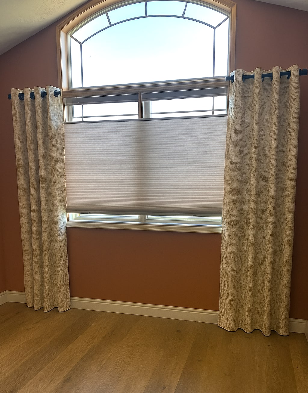 Top down/bottom up cellular shades with decorative panels on either side in tall window