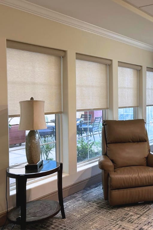 Roller shades in four windows inside country club