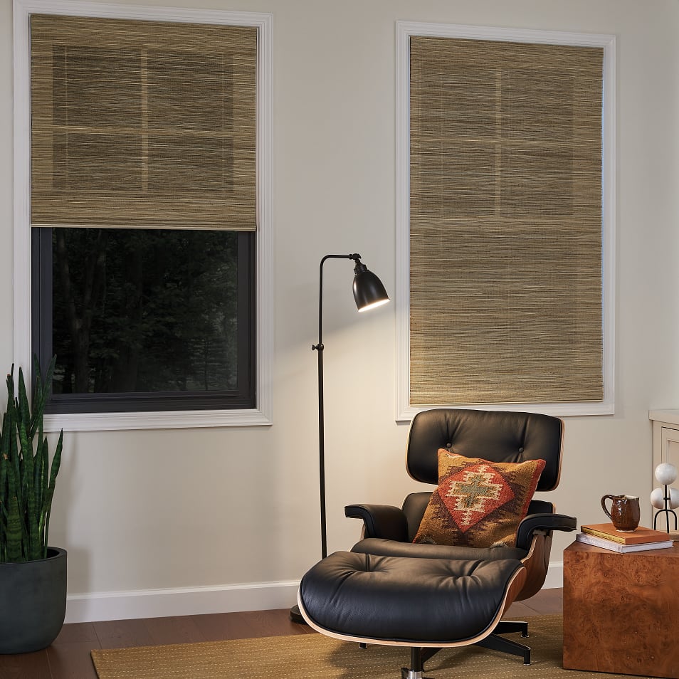 Natural woven wood shades in a neutral luxury study with chair and bookshelf