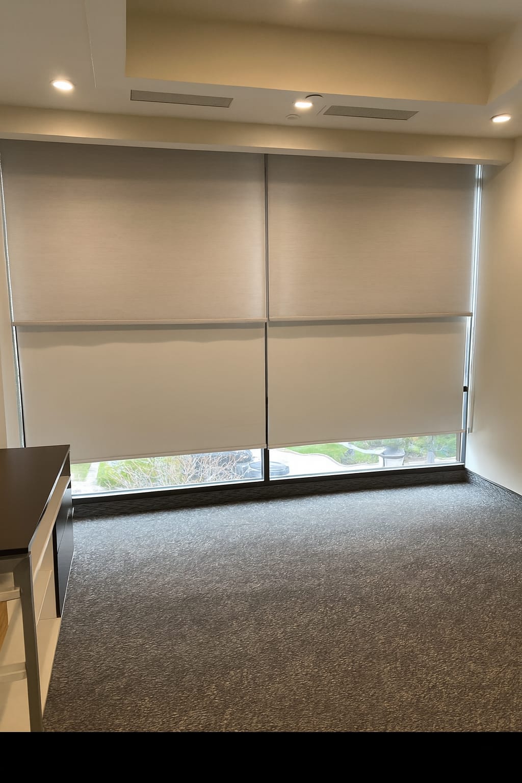 Roller shades in four windows inside country club